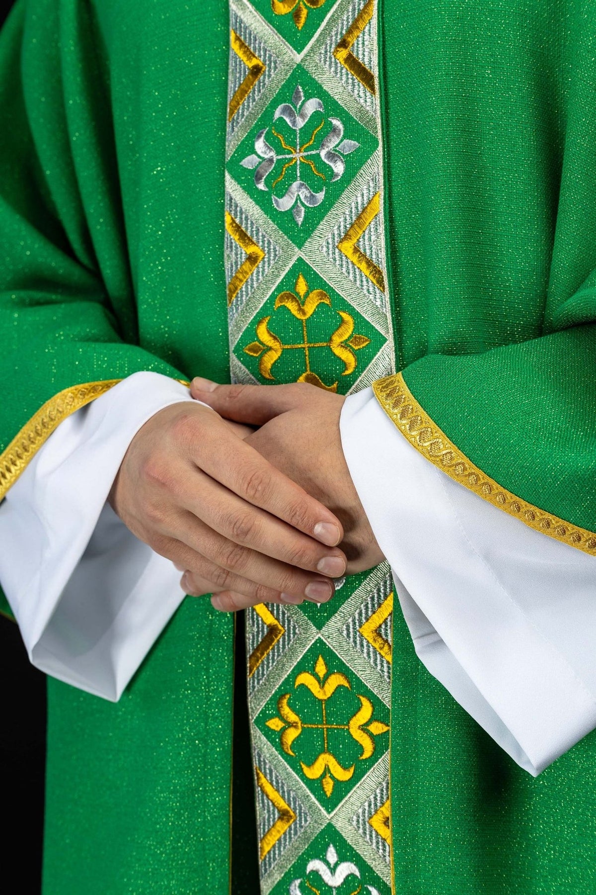 Green chasuble embroidery close-up showing silver and gold motifs on the front orphrey