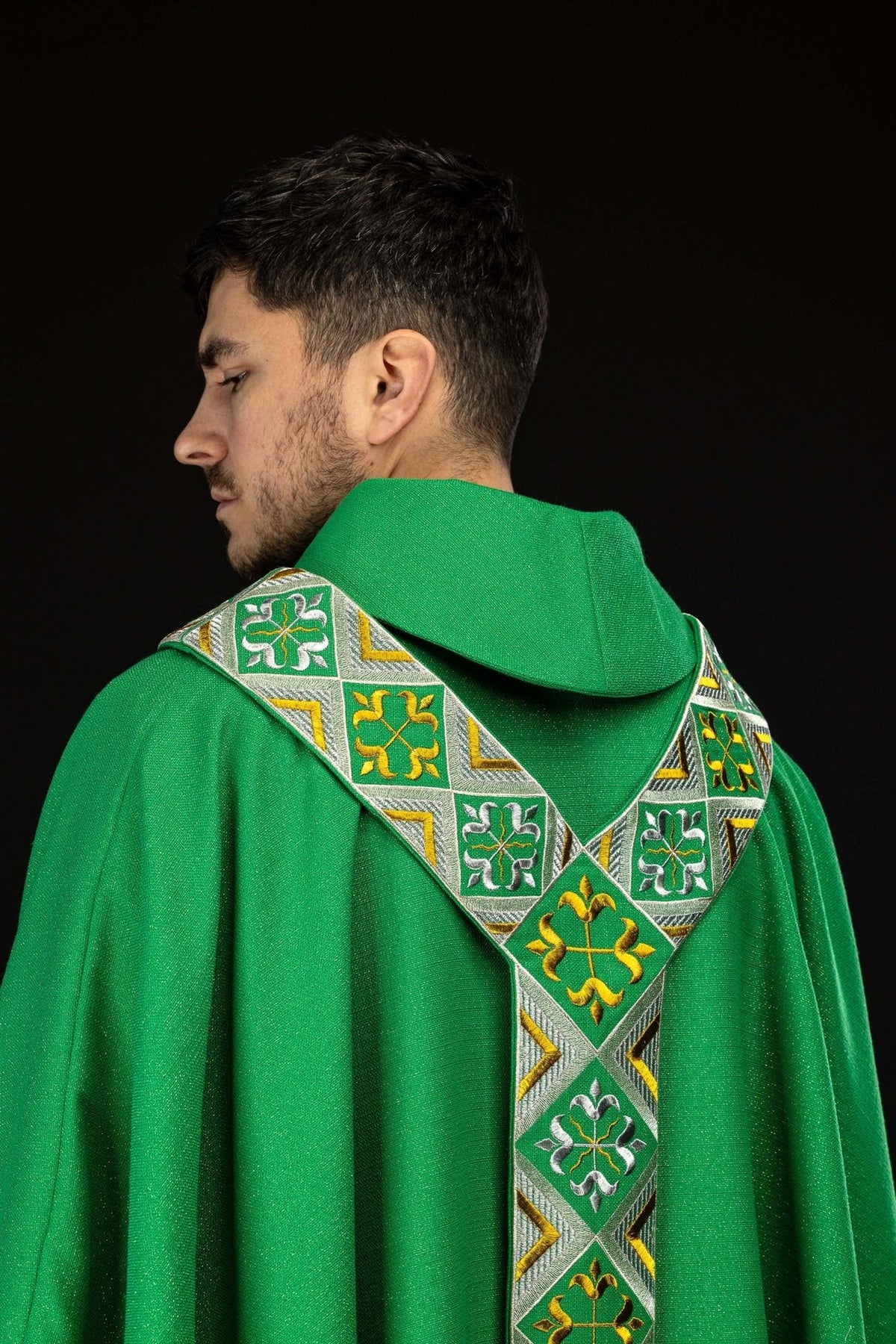 Green chasuble worn from the side and back, showing the embroidered orphrey over the shoulders