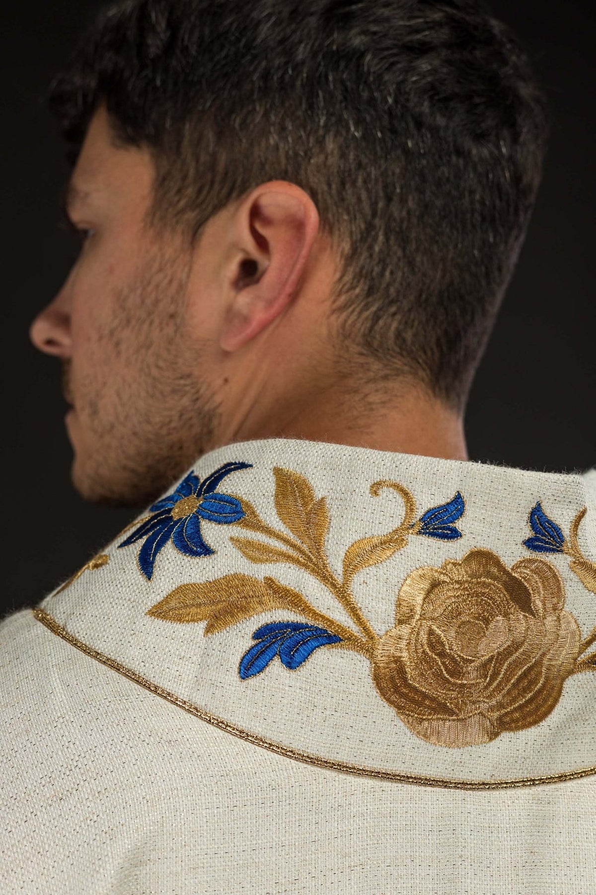 Ecru chasuble detail showing gold trim on the sleeve edge