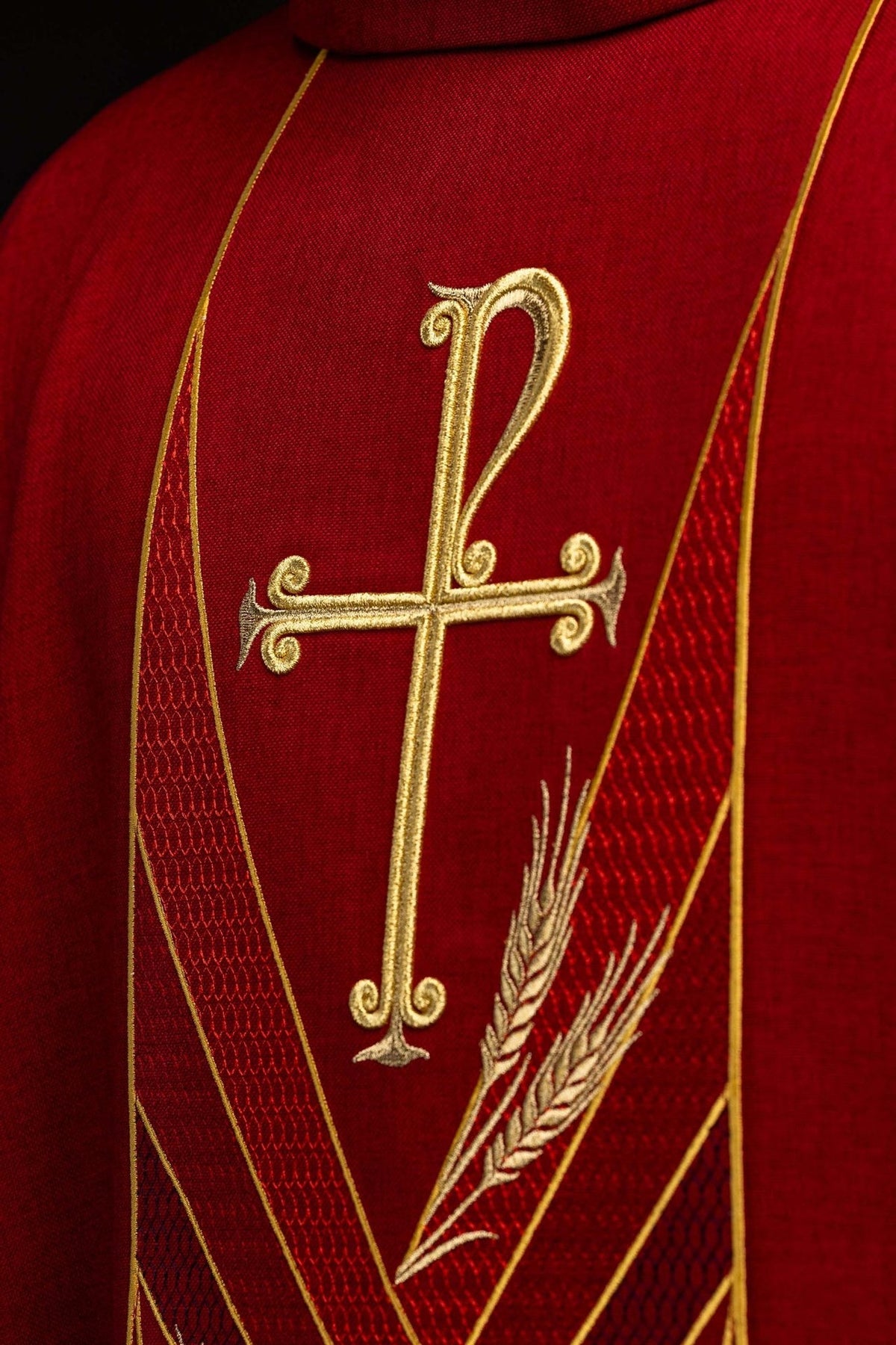 Red chasuble orphrey close-up with embroidered gold cross and wheat