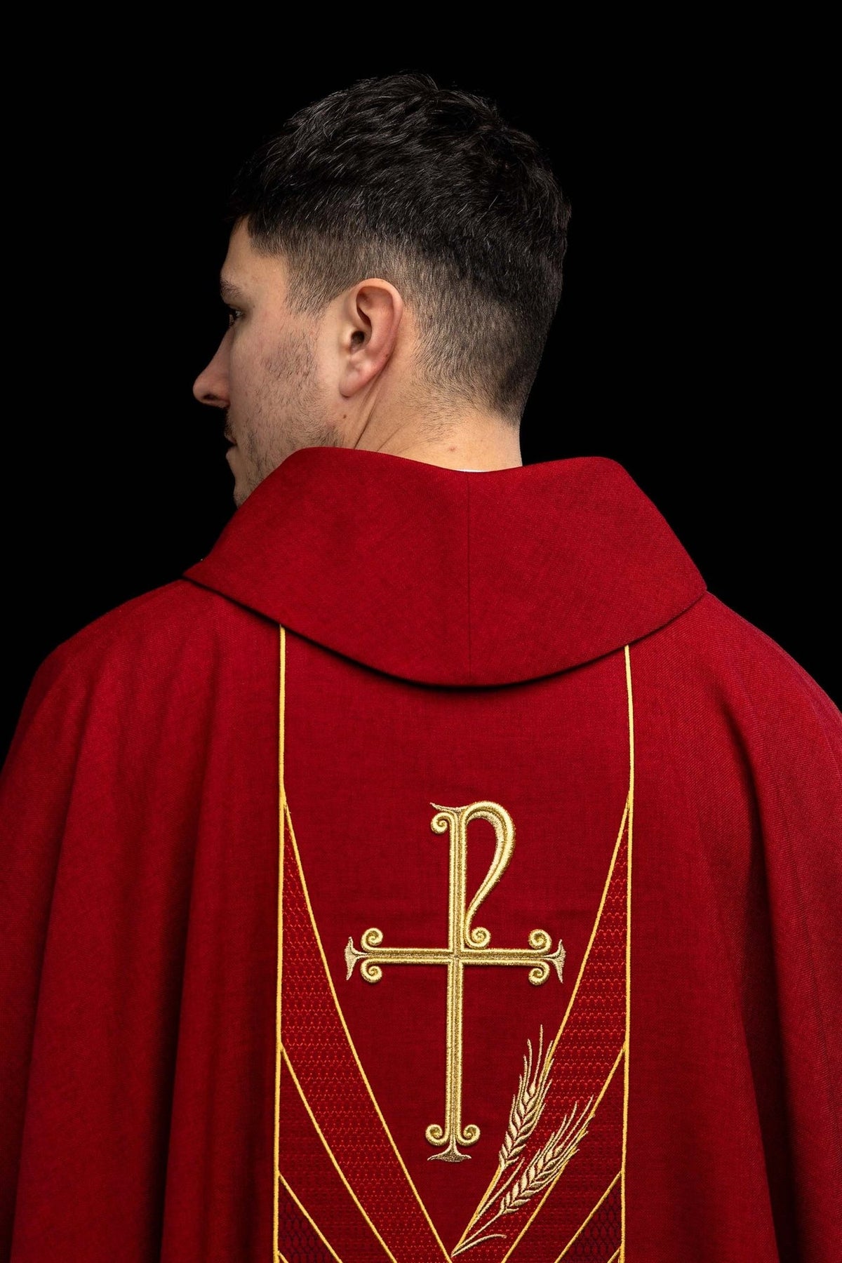 Red chasuble front worn close-up with gold cross and wheat orphrey