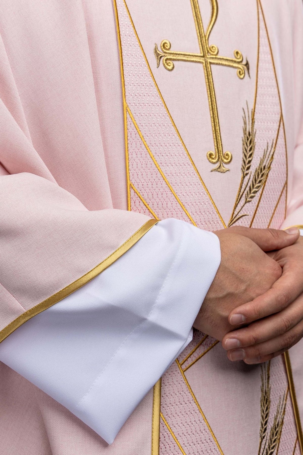 Rose chasuble close-up showing gold-trimmed sleeve edge and wheat embroidery