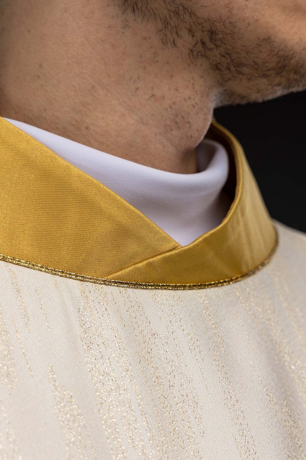 Ecru chasuble detail showing gold trim and woven fabric
