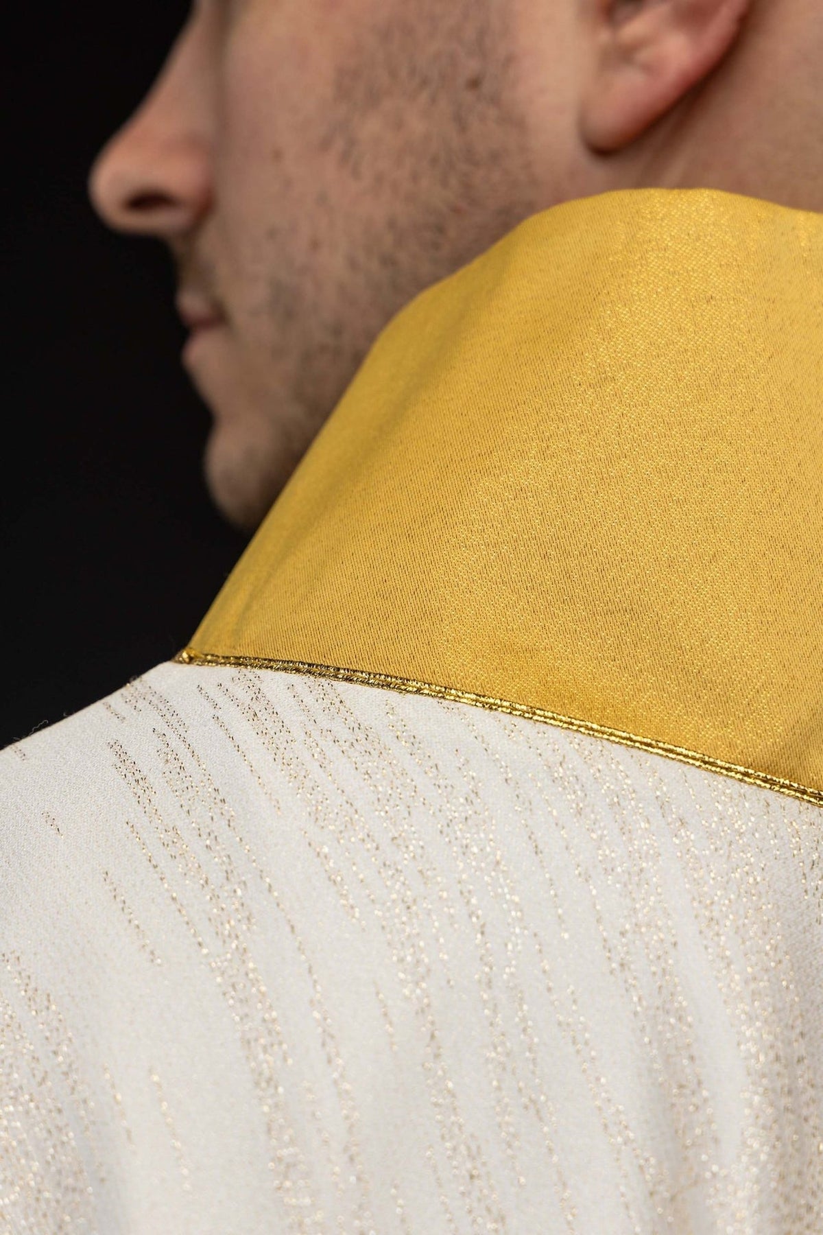 Chasuble detail showing gold collar trim and ecru fabric