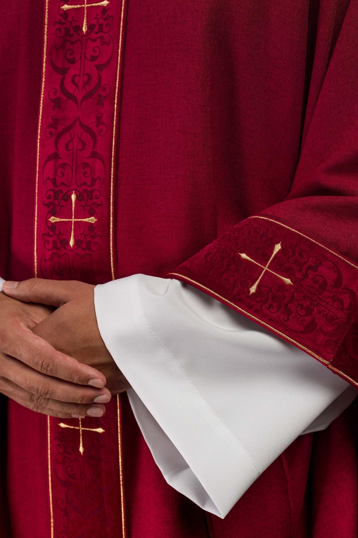 Red chasuble close-up of gold cross embroidery and patterned orphrey