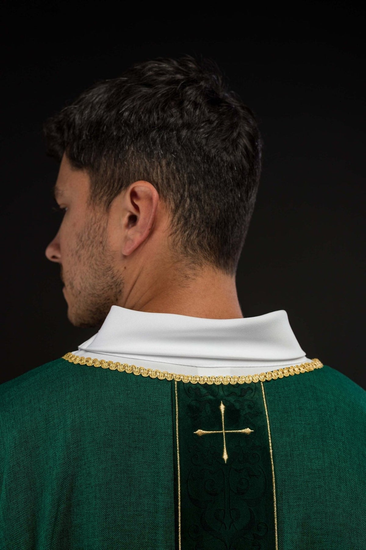 Green chasuble back close-up with embroidered orphrey and gold cross