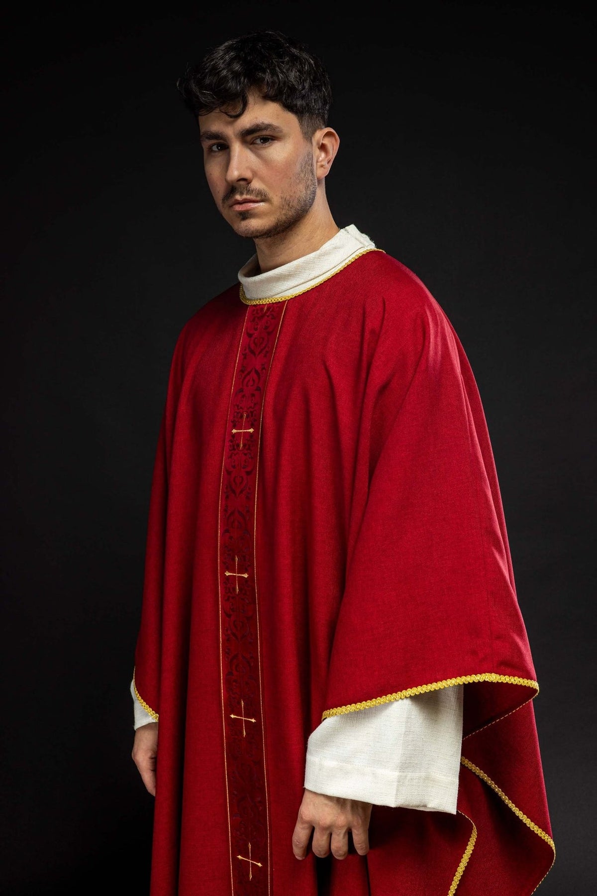Red chasuble, angled front view with gold trim and embroidered orphrey