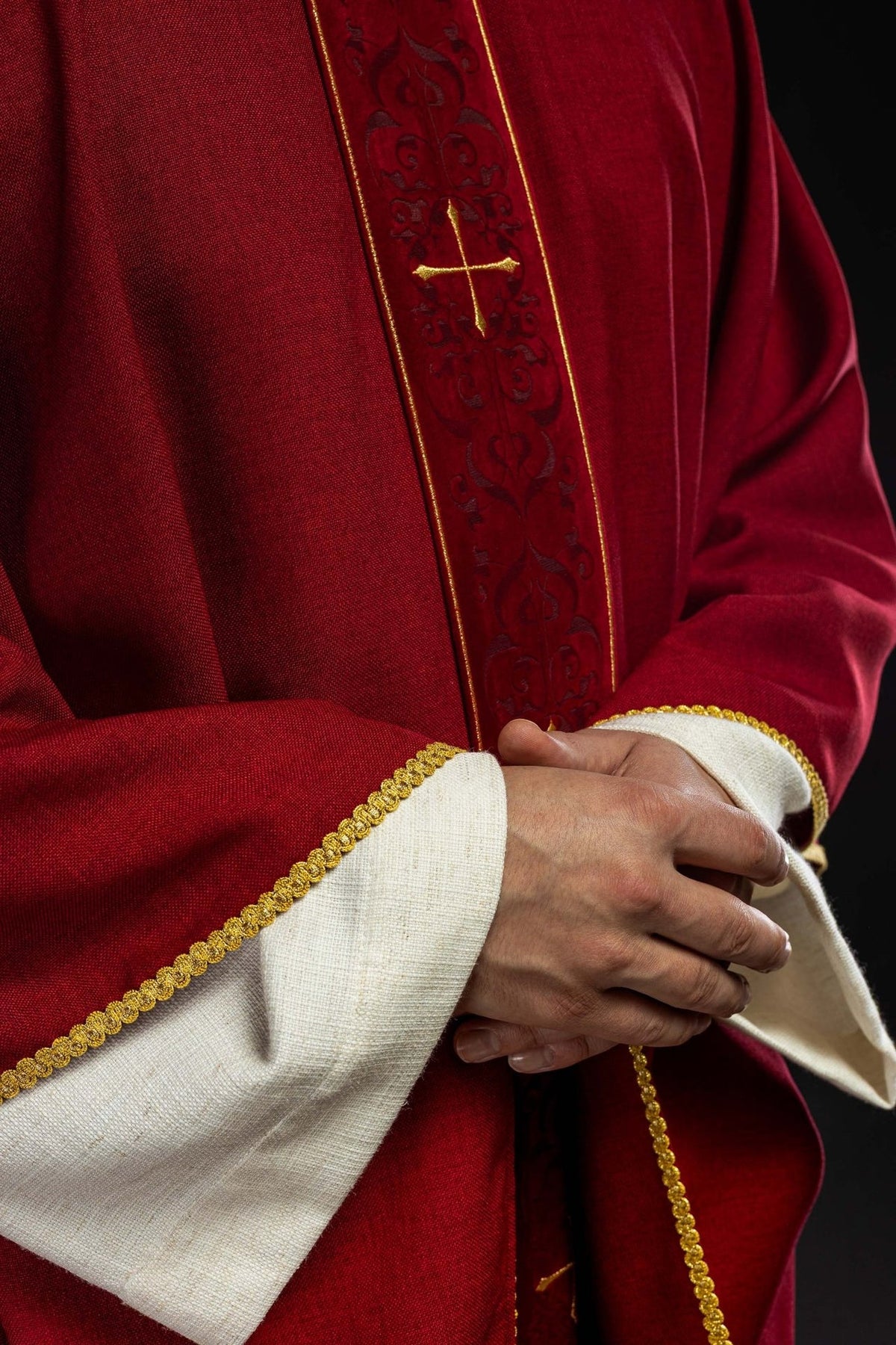 Red chasuble close-up with embroidered orphrey and gold cross