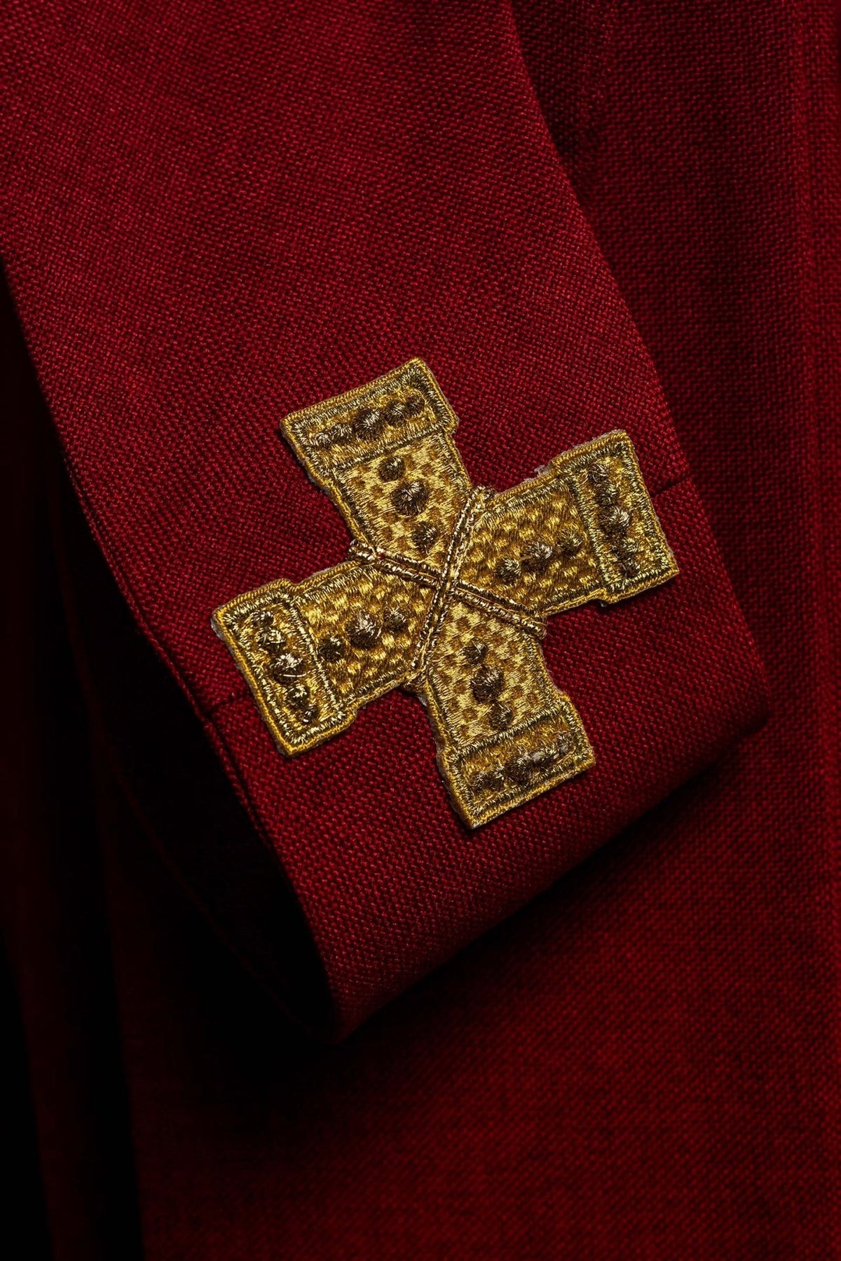 Red chasuble detail with gold cross embroidery and tassels