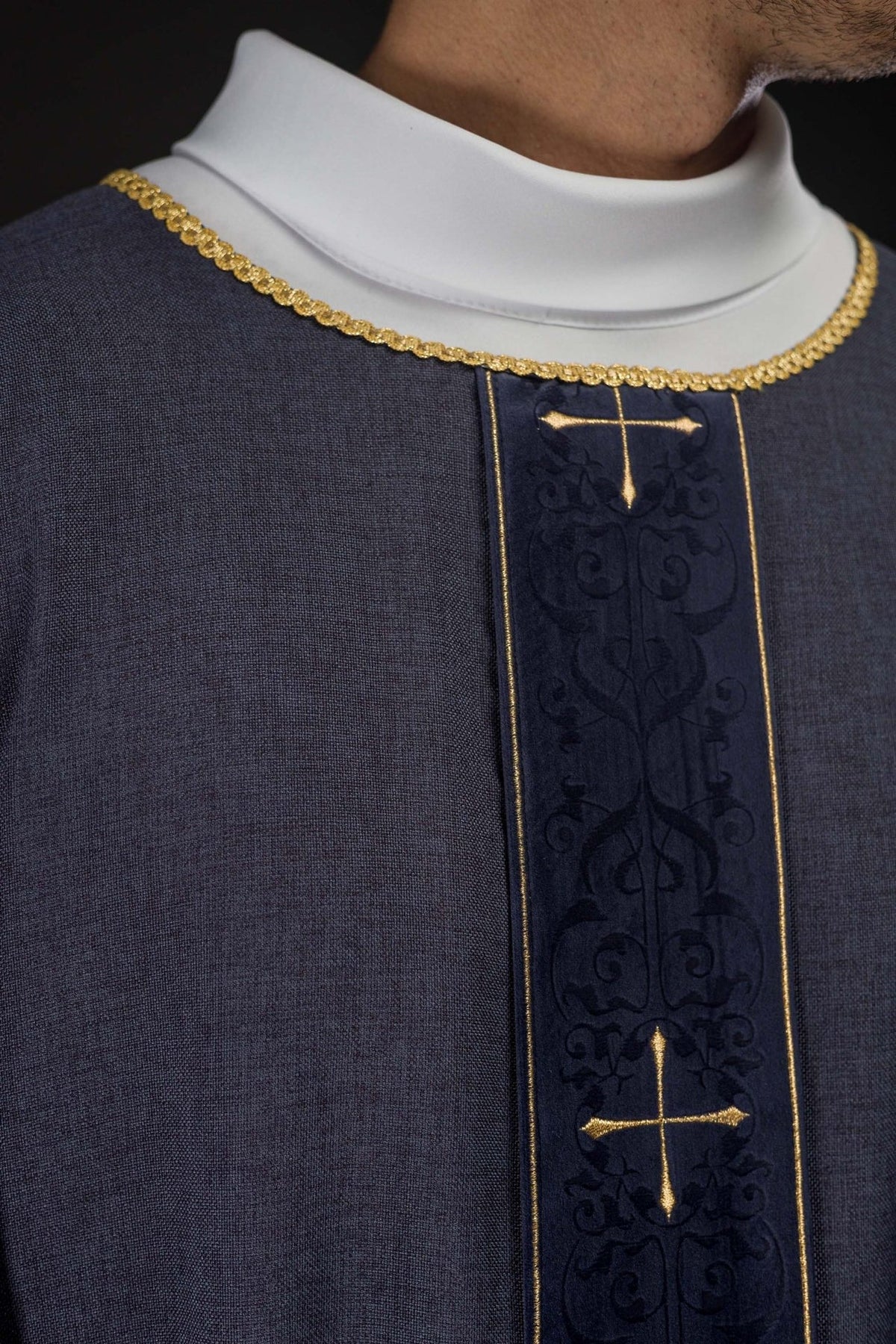 Purple chasuble close-up showing gold trim and embroidered orphrey with crosses