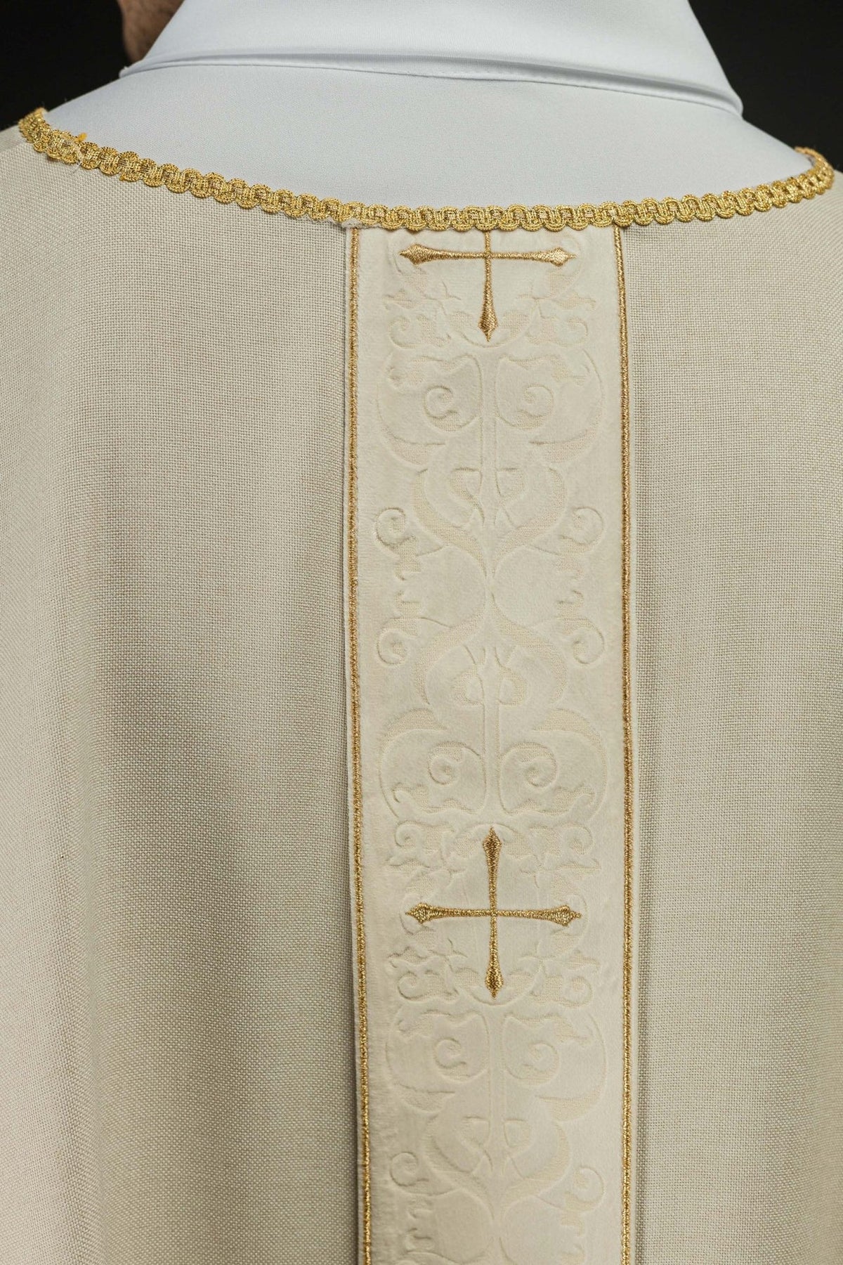 Ecru chasuble back close-up with embroidered orphrey and gold crosses