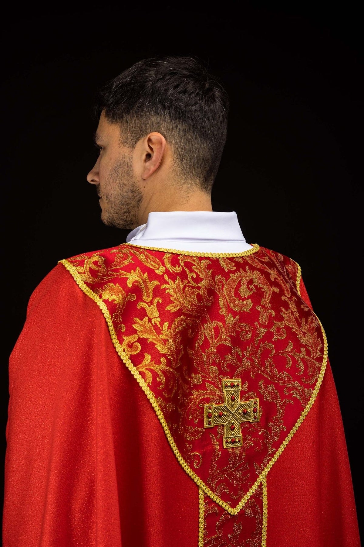 Red chasuble close-up of gold cross and floral jacquard orphrey