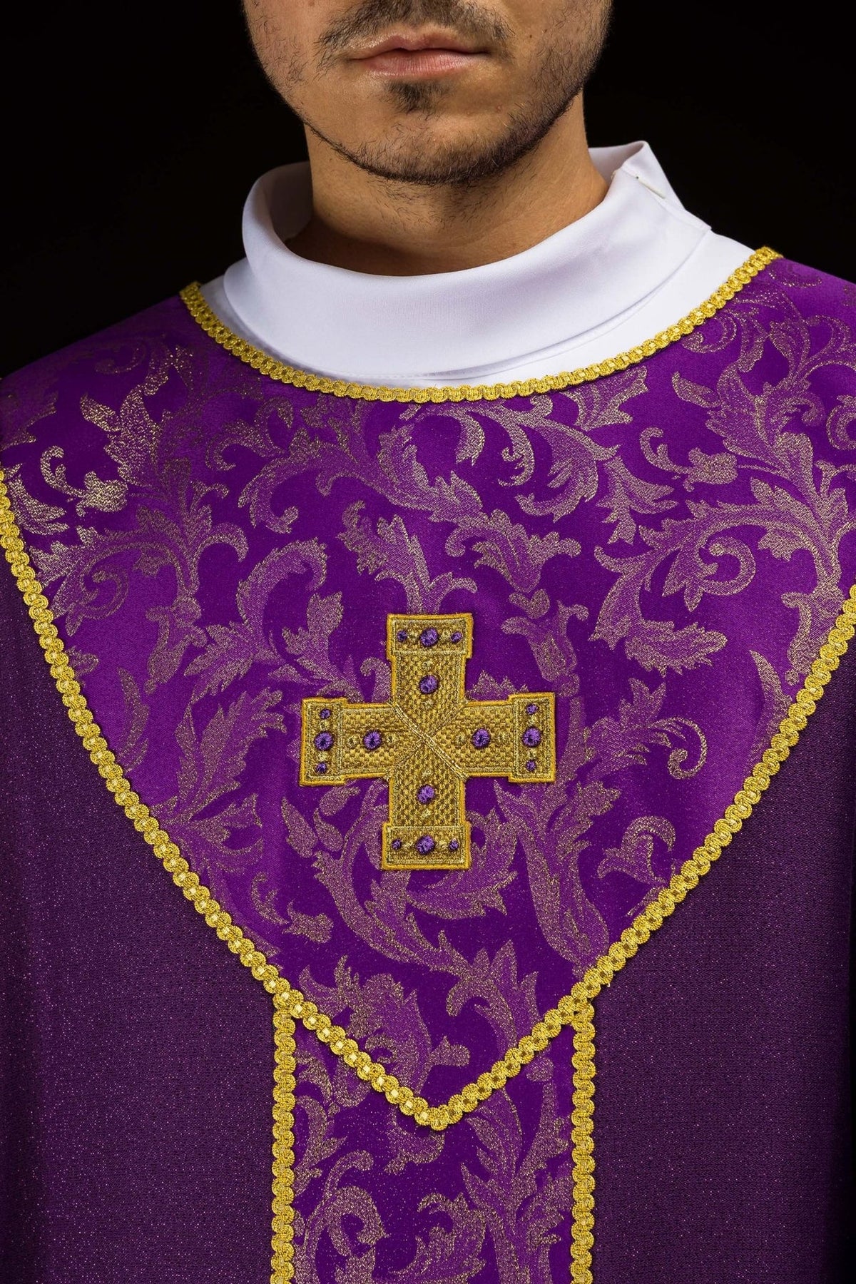 Purple chasuble close-up with gold cross and jacquard fabric