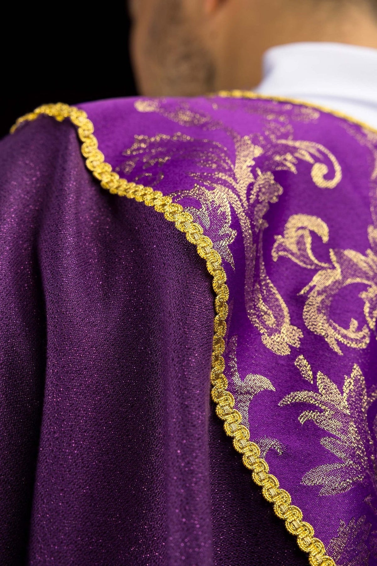 Purple chasuble sleeve detail with gold trim and white cuff