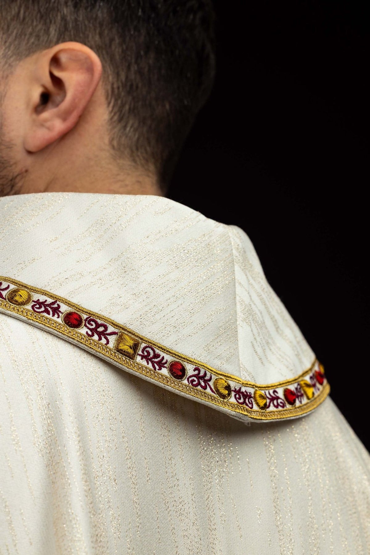 Chasuble back view with cream fabric and embroidered communion chalice emblem