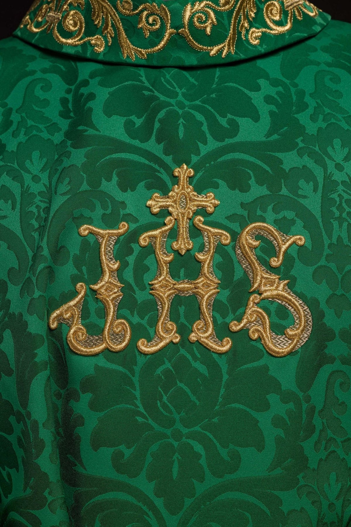 Green chasuble close-up with gold IHS embroidery and floral satin pattern
