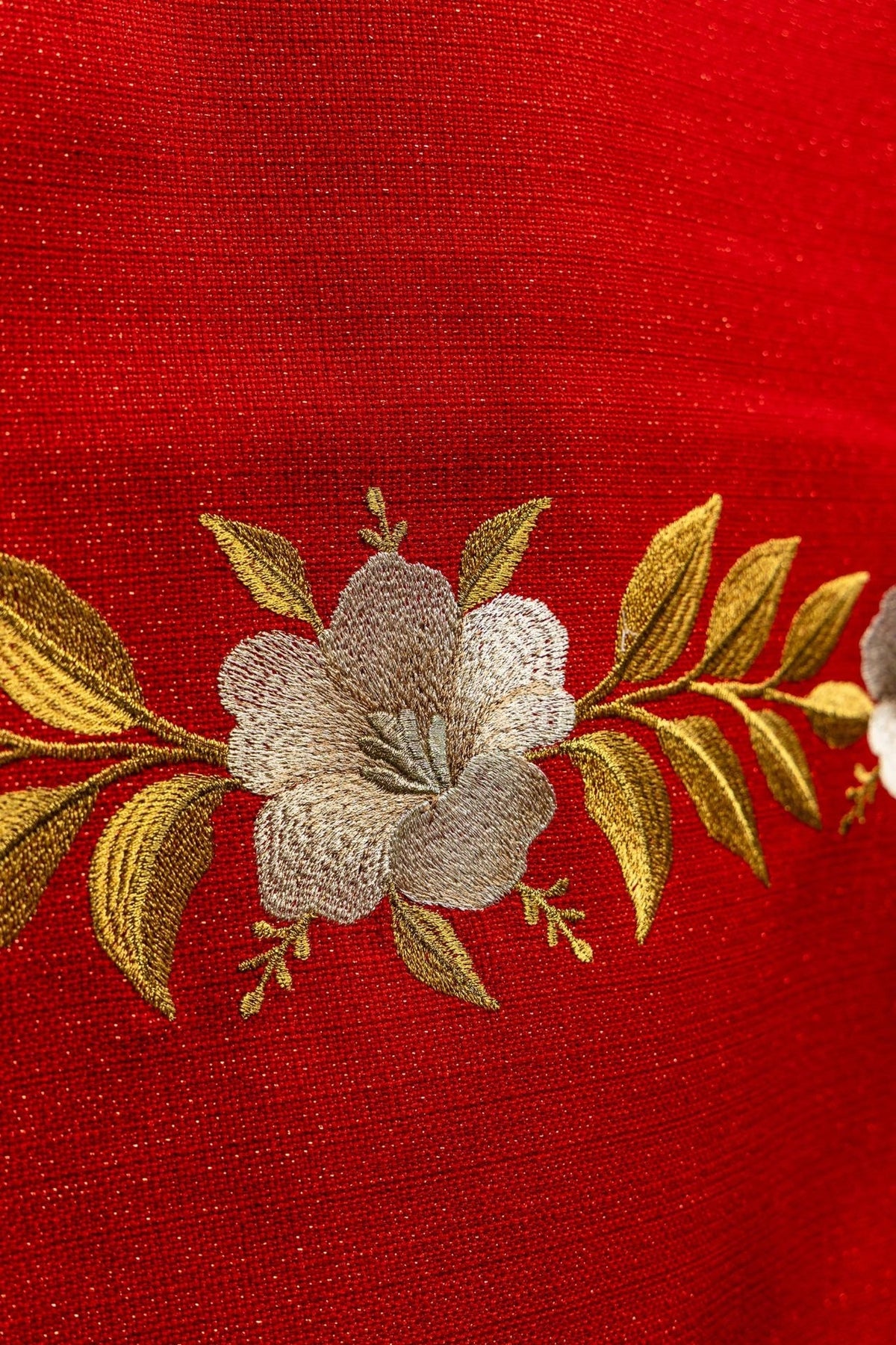 Church lectern cover close-up of embroidered gold and silver floral motif on red fabric