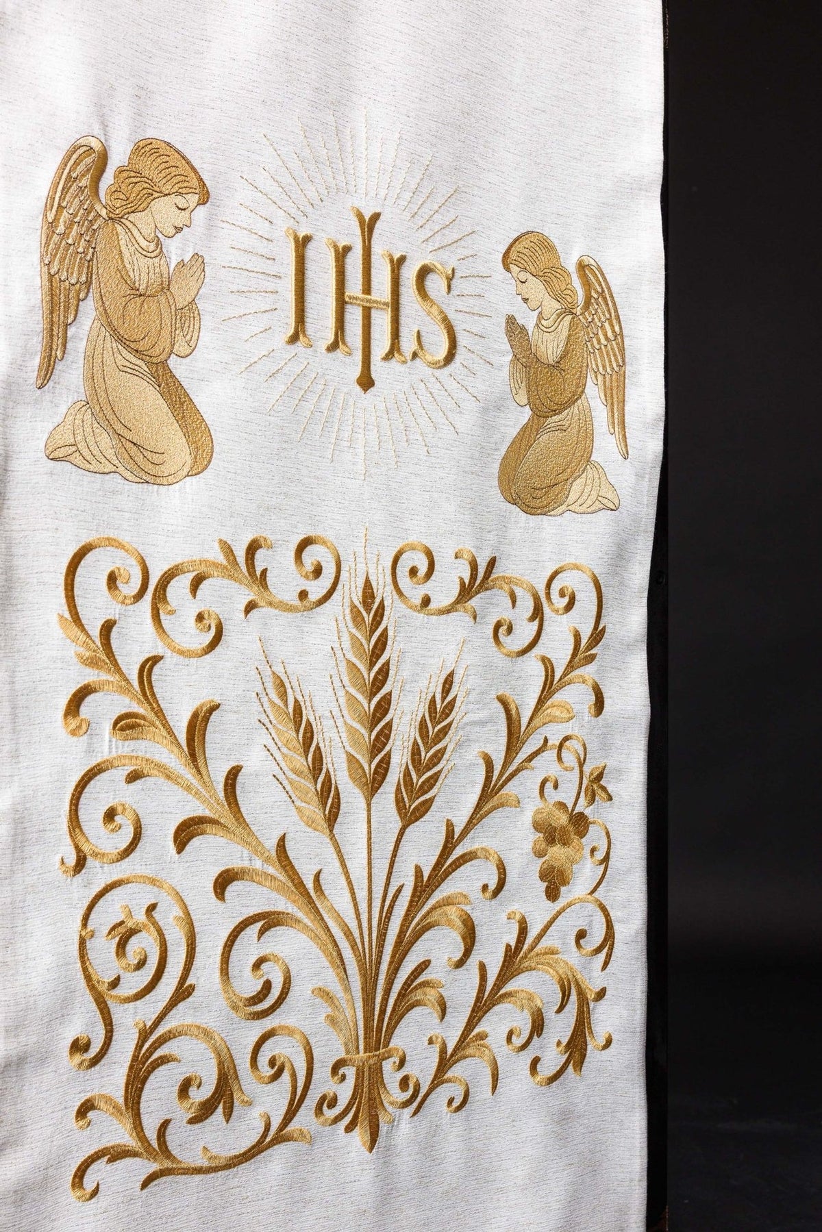 Ecru church lectern cover close-up with gold IHS monogram and kneeling angels