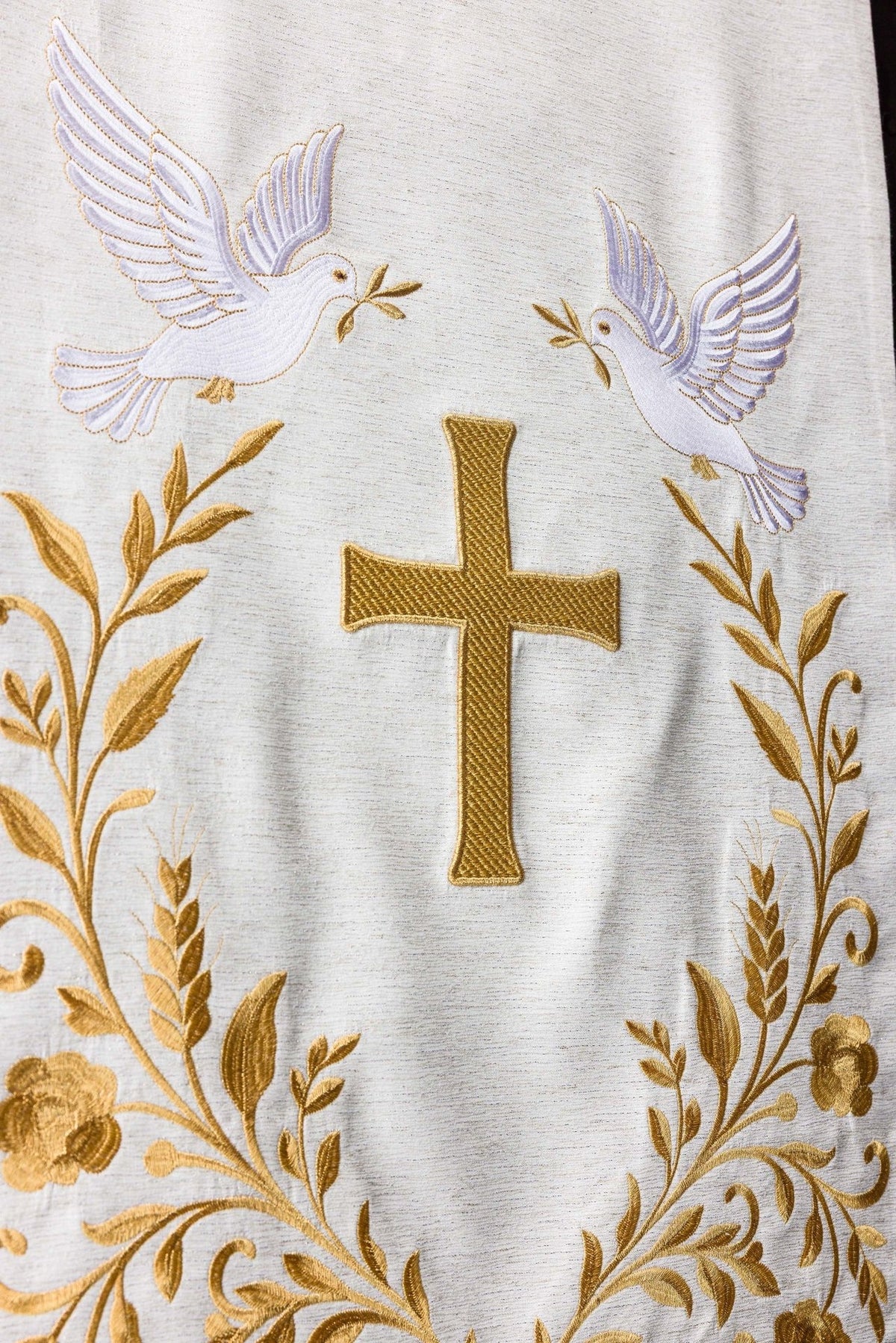 Church lectern cover close-up showing white doves, gold cross and floral embroidery
