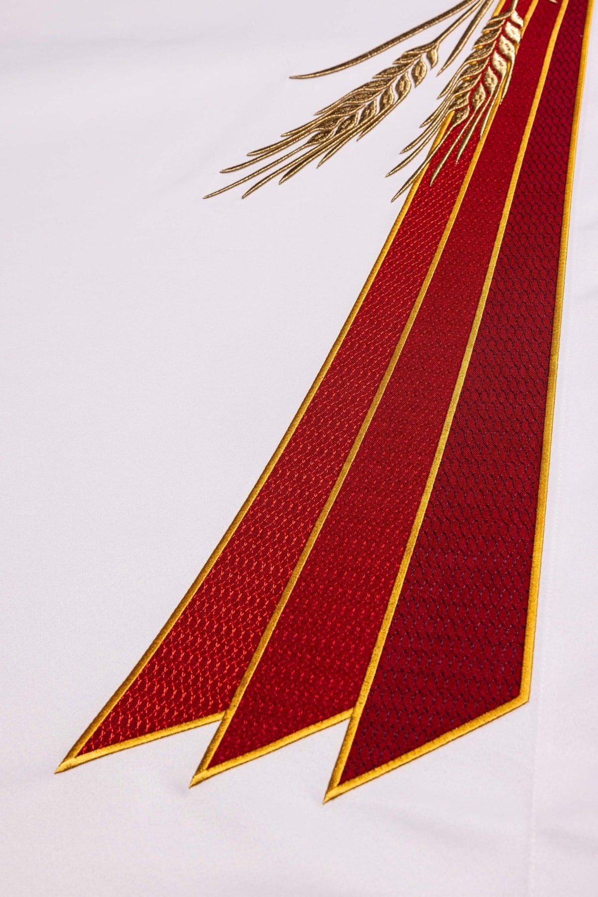 Altar cloth detail showing red embroidered bands with gold edging and wheat embroidery