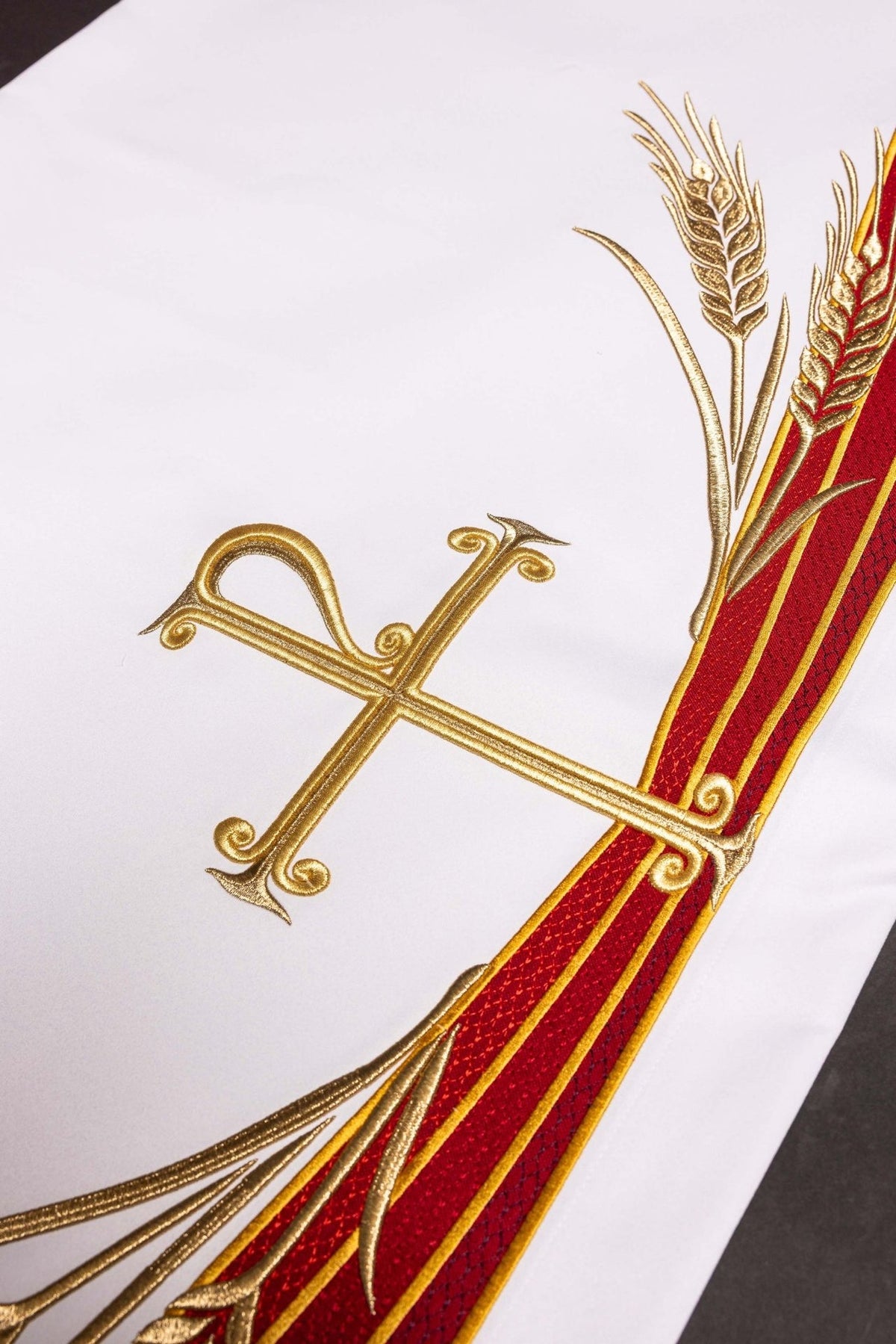 Altar cloth detail showing three red embroidered bands with gold edging
