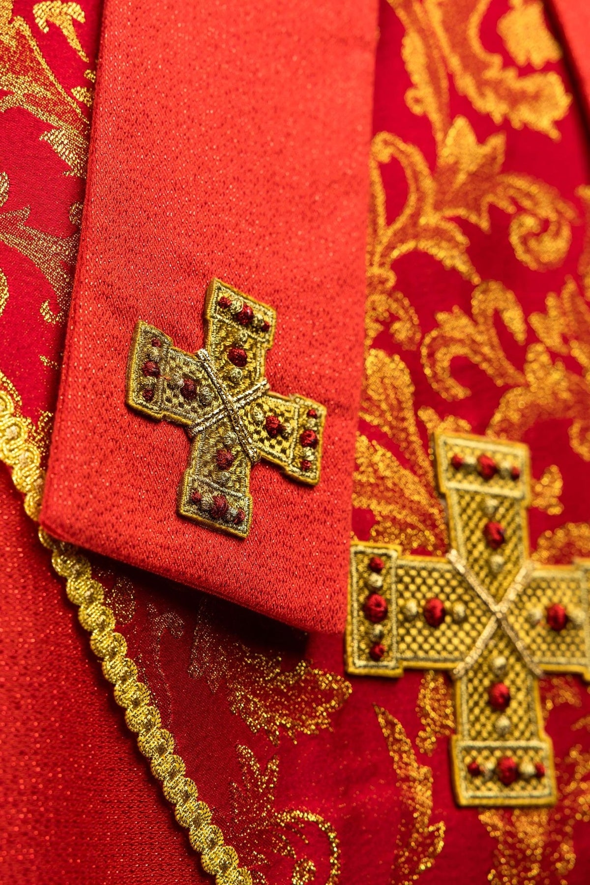 Red miter close-up showing gold embroidered cross and red fabric