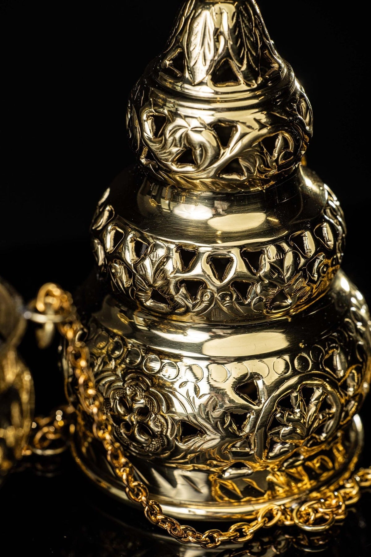 Brass thurible close-up of layered floral and leaf motifs
