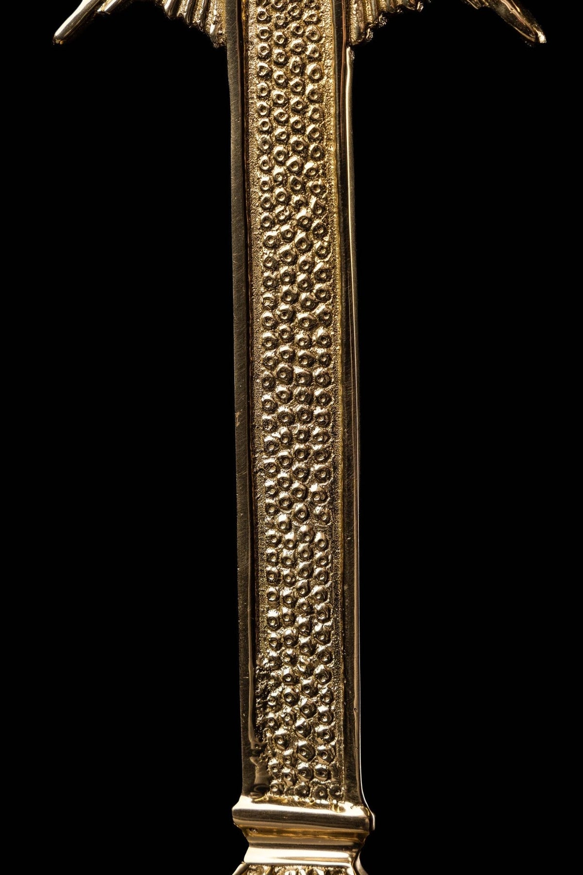 Brass cross reliquary close-up of textured vertical shaft