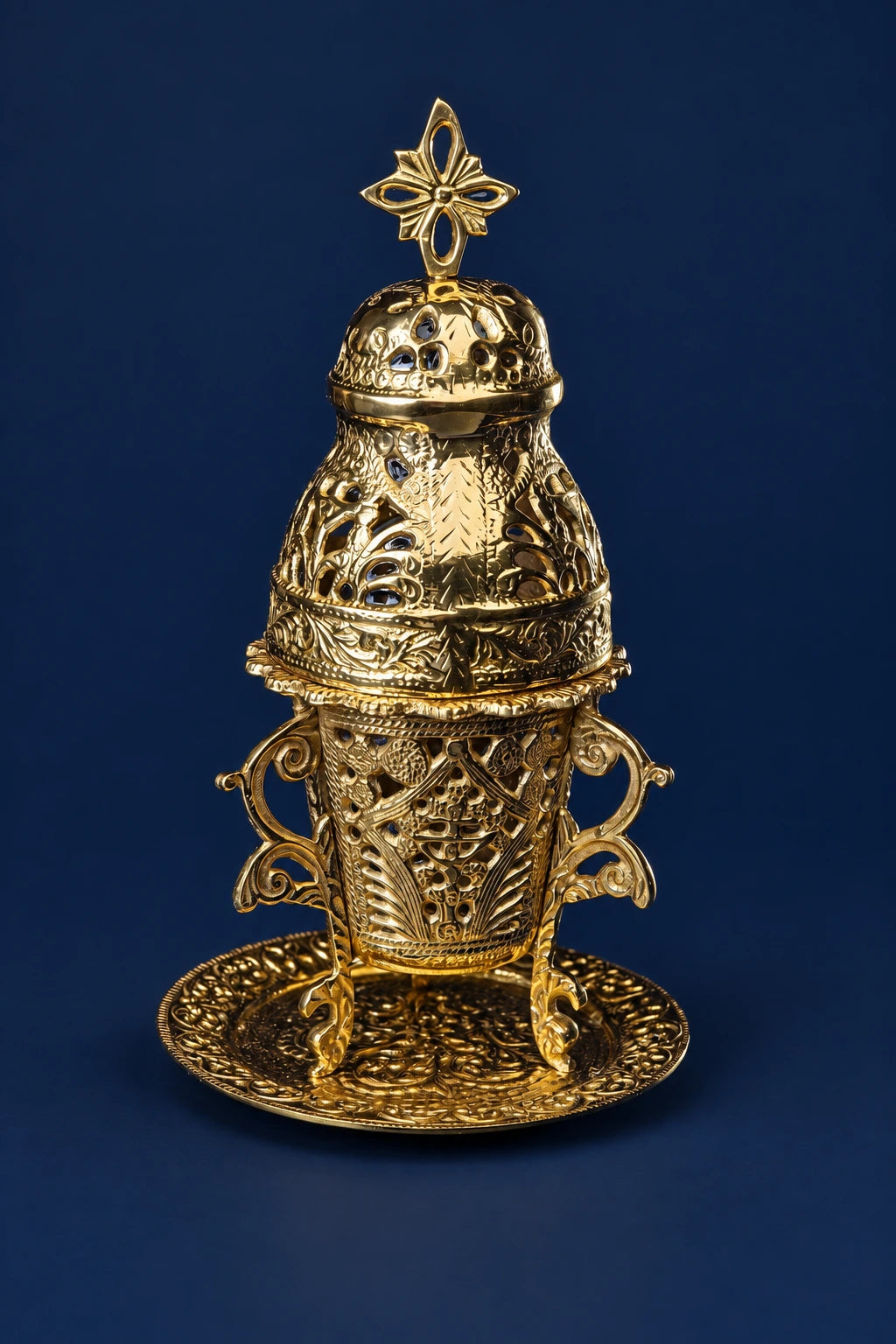 Ornate brass censer on stand with cross finial and pierced filigree body, front view