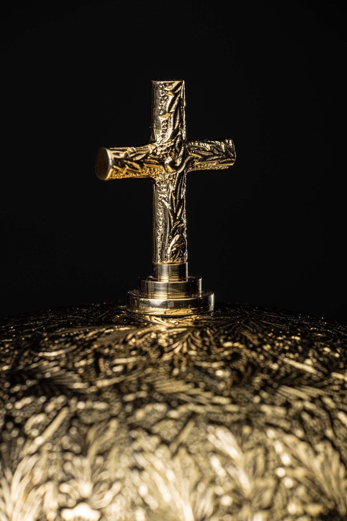 Brass altar bells, close-up of engraved cross and floral dome