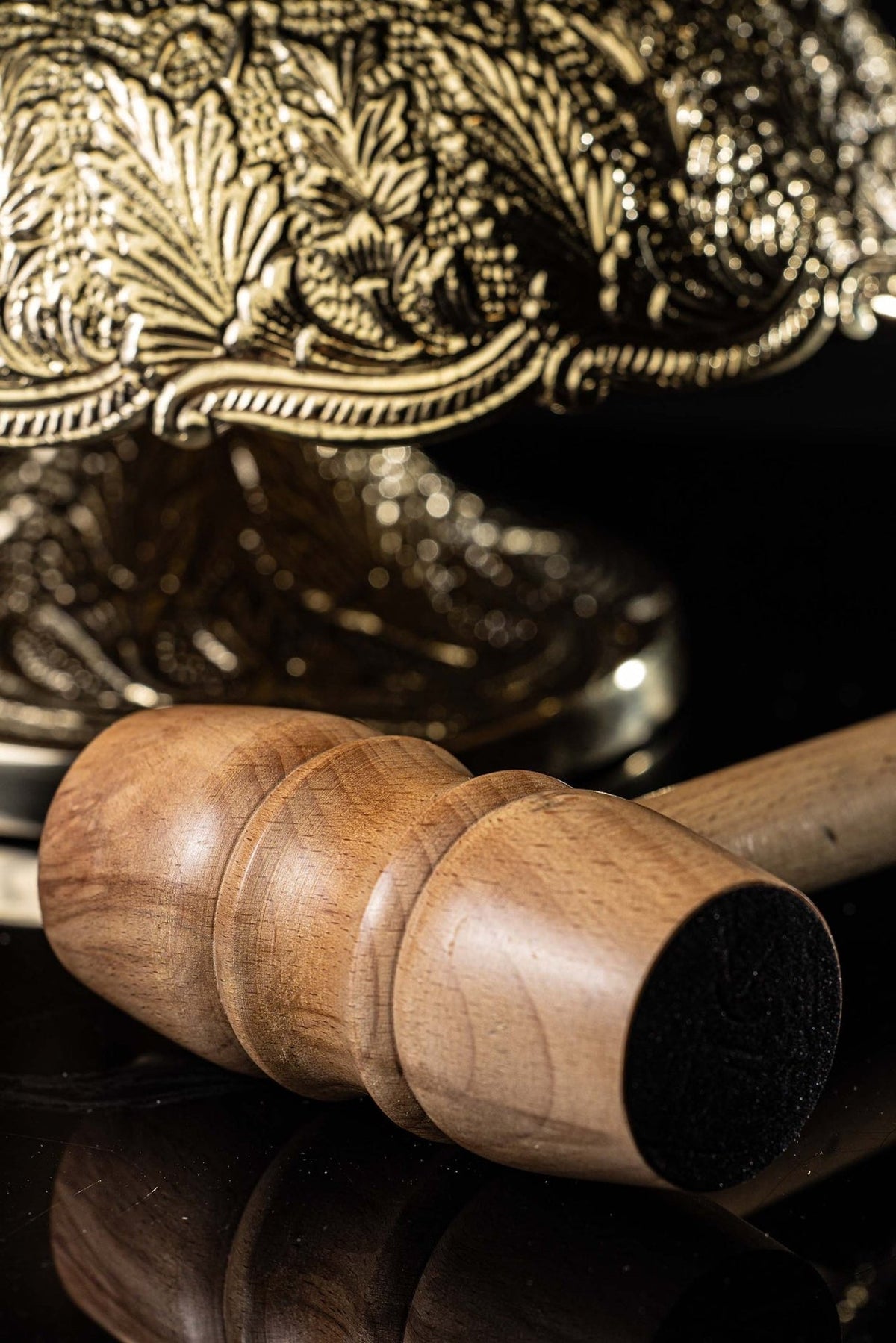 Wooden mallet for altar bells, close-up of turned handle and black striking end