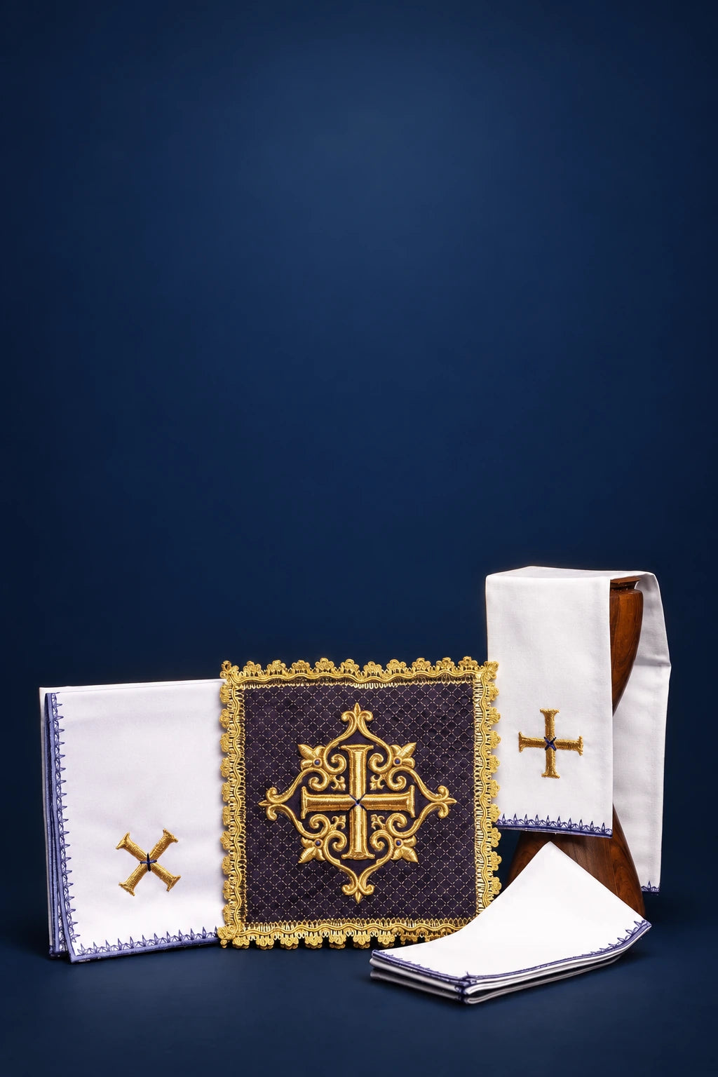 Purple altar linen set with embroidered gold cross, folded cloths and ornate square cover displayed together