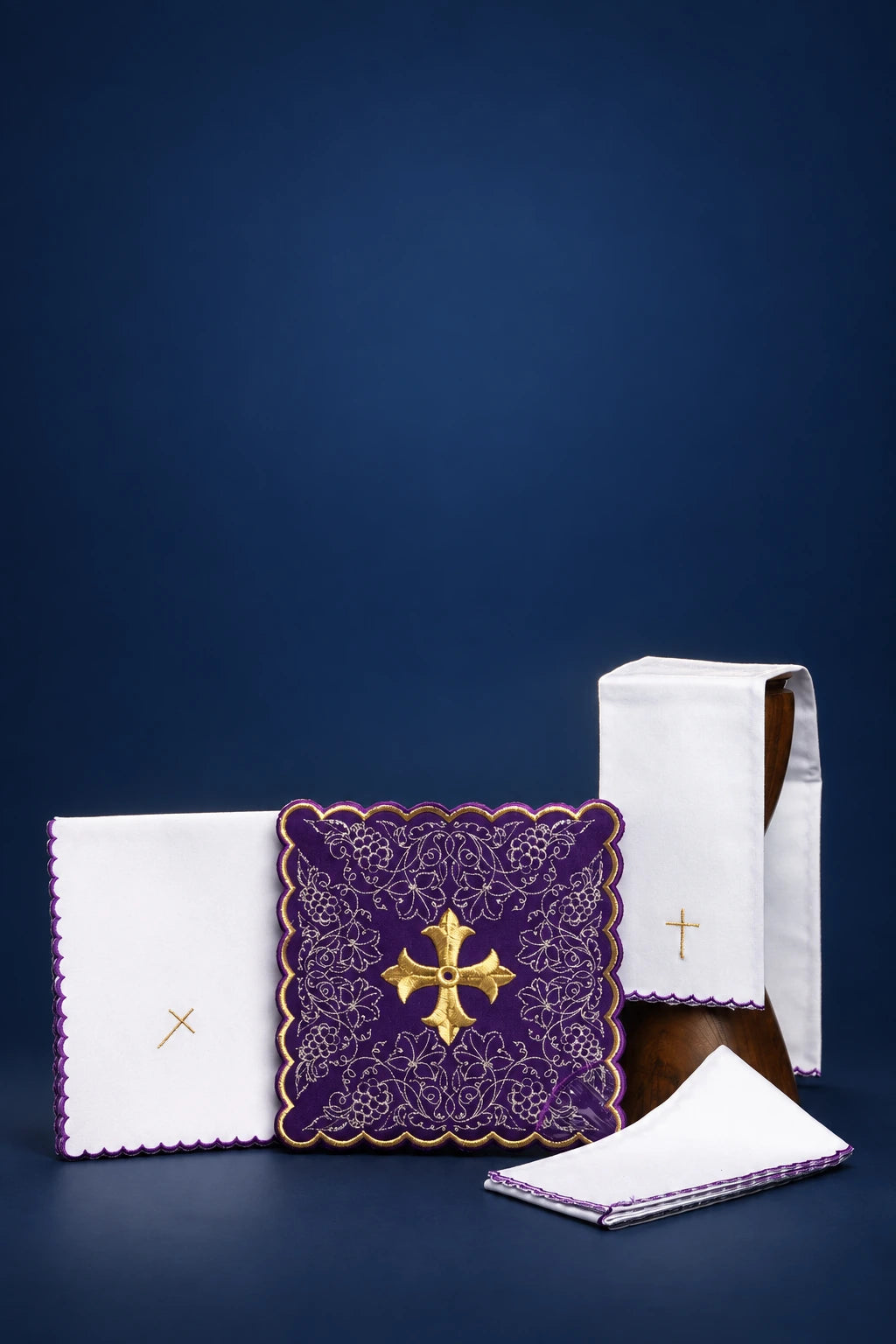 Purple altar linen set with gold cross and vine motif, shown with folded linens and veil