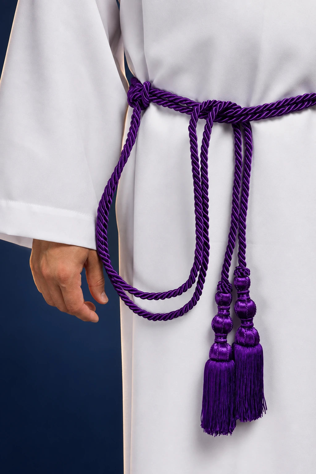Purple braided cincture tied at the waist, with long hanging cords and tassel ends