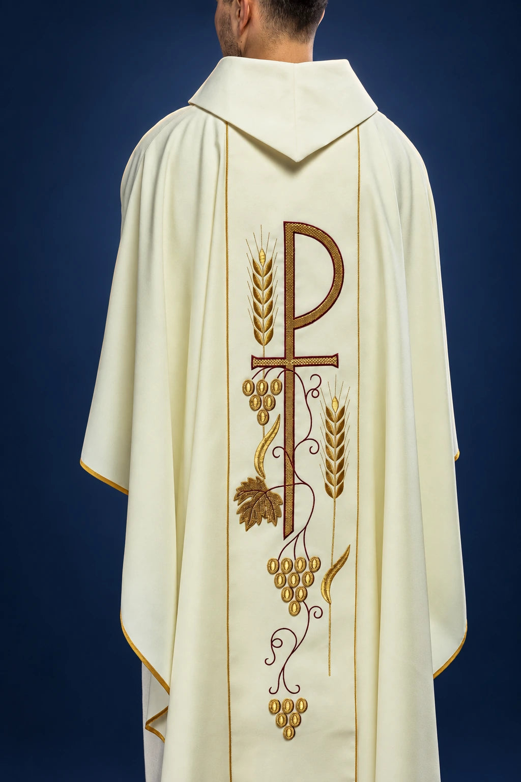 Rear view of an ecru chasuble with pointed hood and central wheat-and-grape embroidery with gold trim