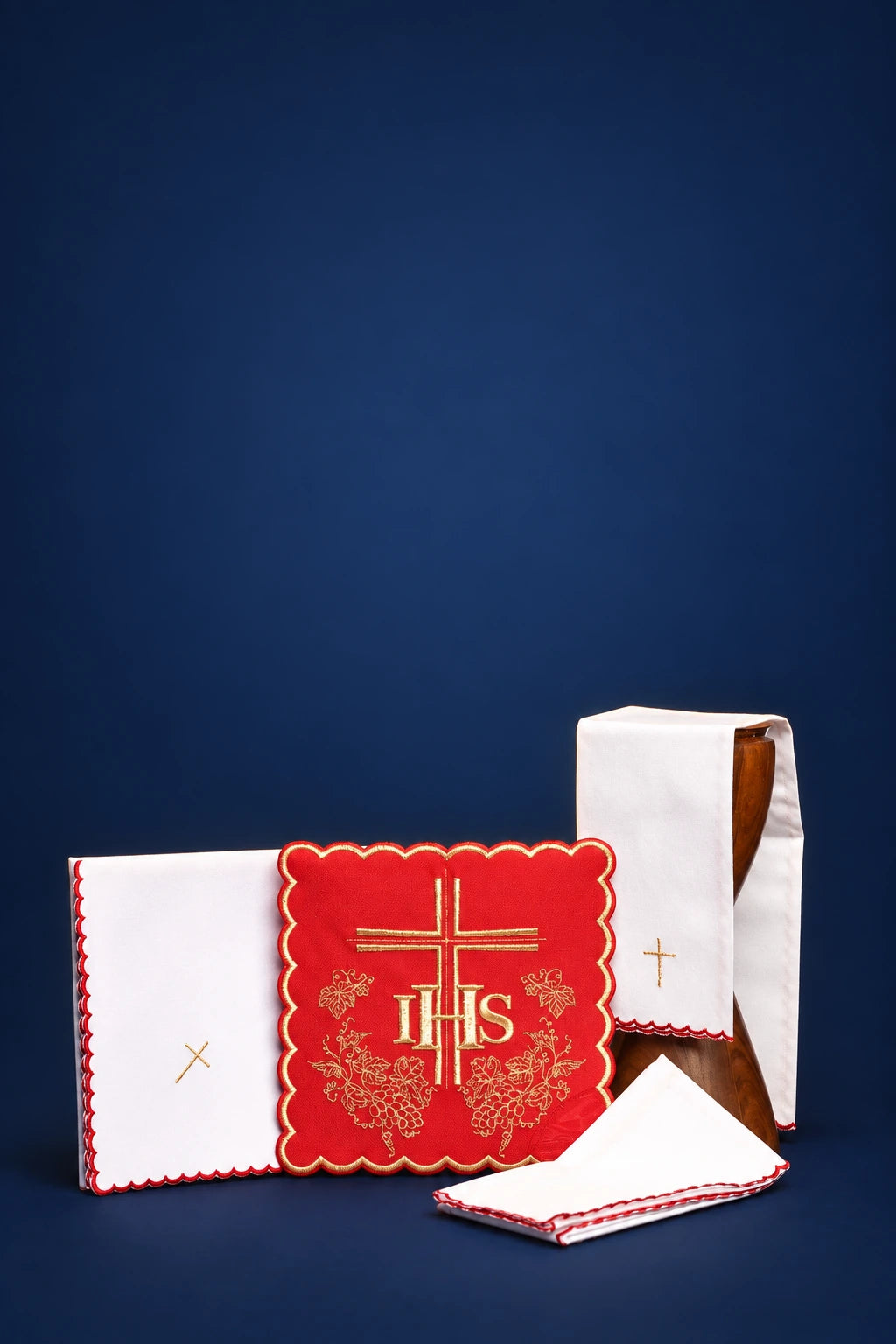 Red altar linen set with gold IHS embroidery, including folded cloths and a purificator front view
