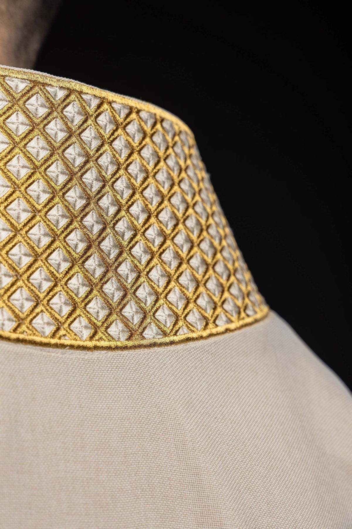 Ecru dalmatic close-up showing gold embroidered collar pattern