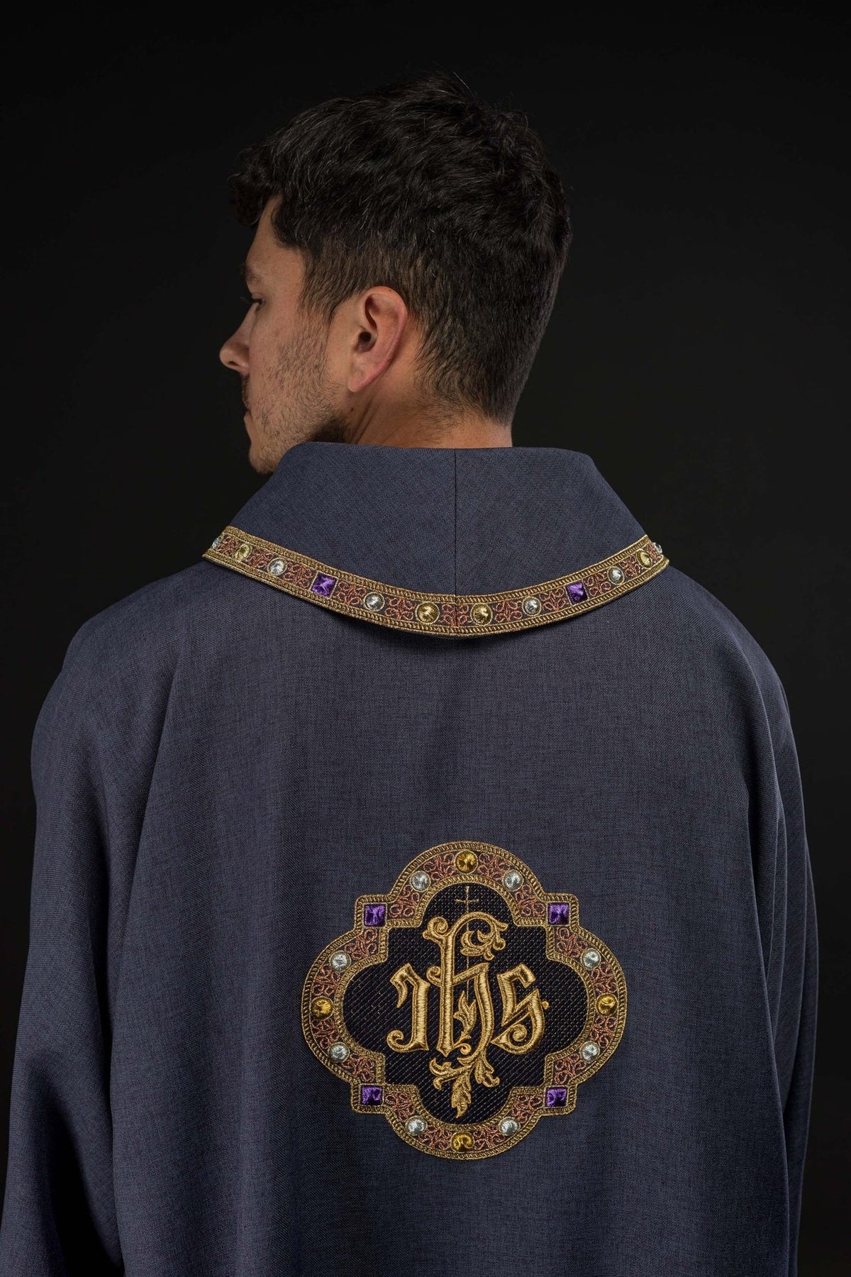 Purple dalmatic back view with embroidered IHS symbol and decorative collar trim