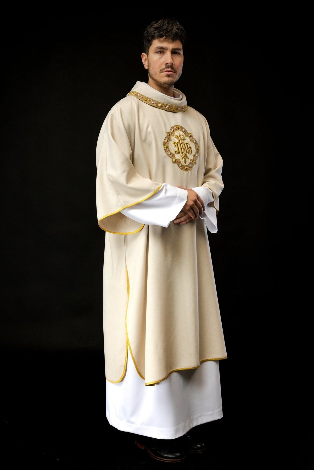 Ecru dalmatic three-quarter front view with embroidered IHS symbol and gold trim