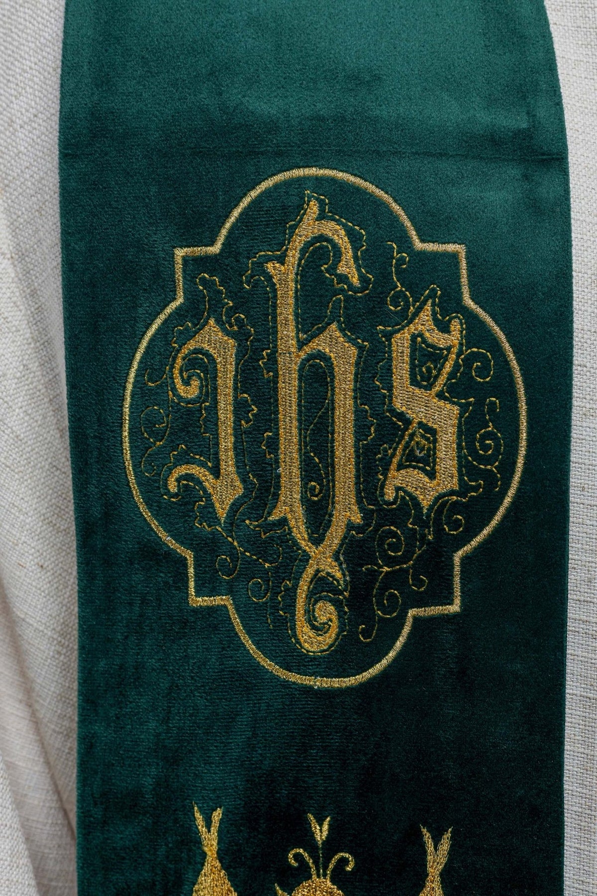Green stole close-up showing gold embroidered IHS motif