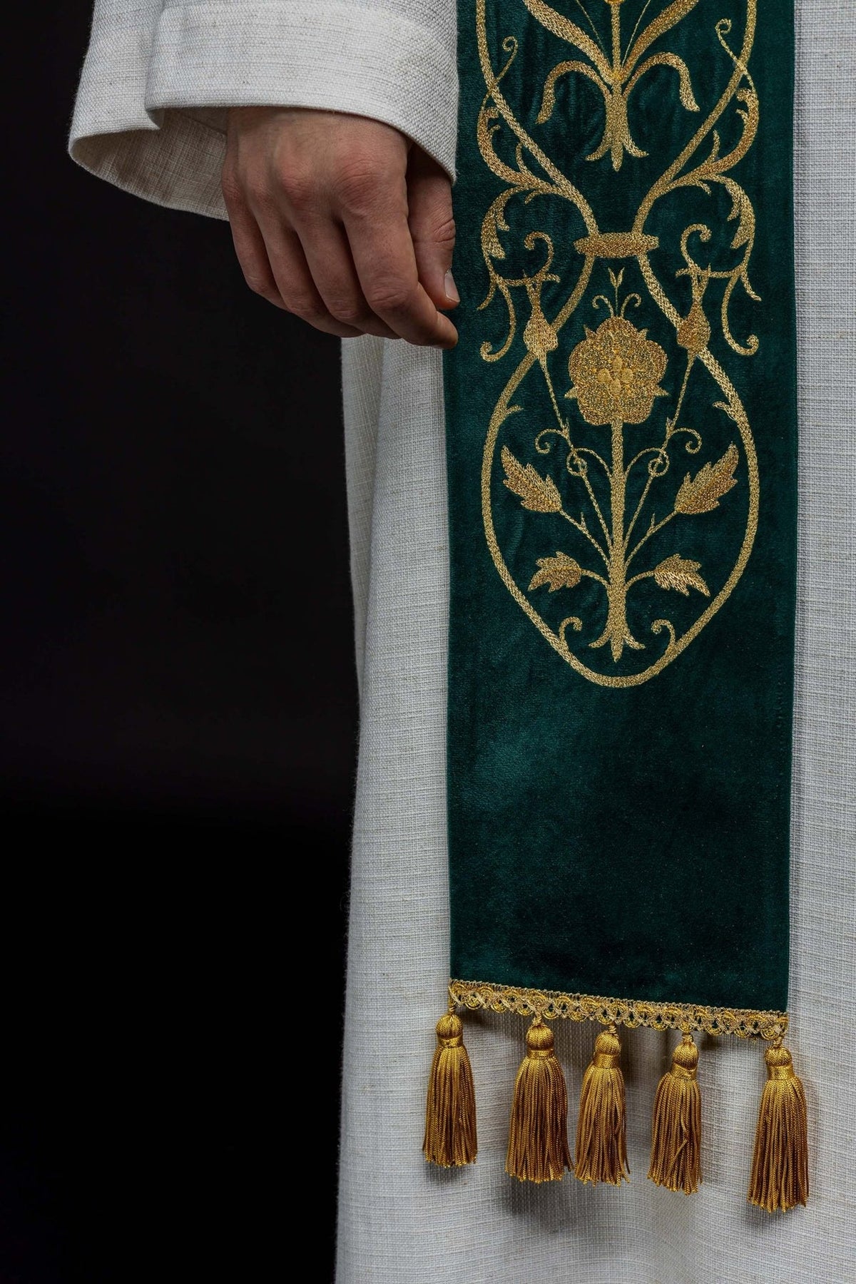 Green stole worn close-up showing gold floral embroidery and lower section