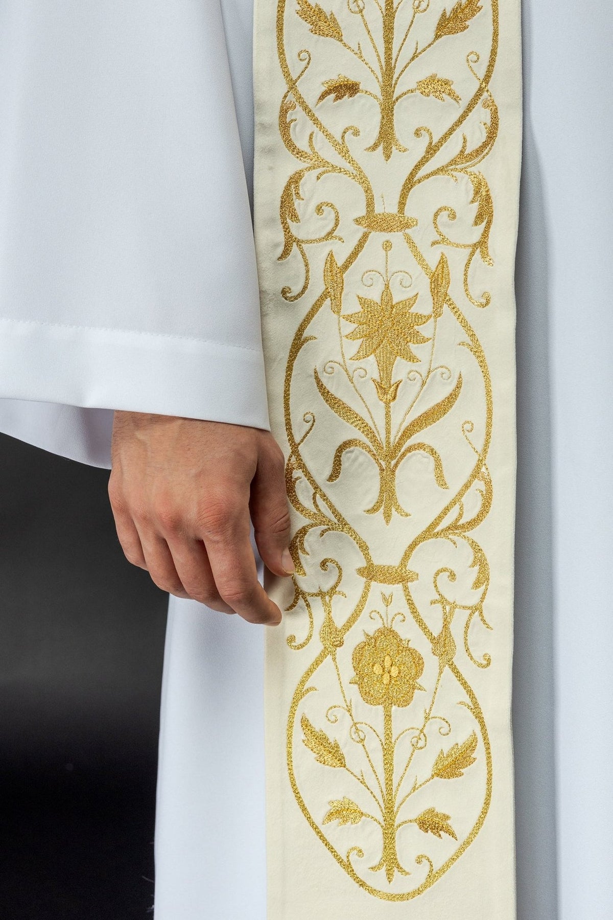 Ecru stole close-up showing gold floral embroidery and scrolling vines