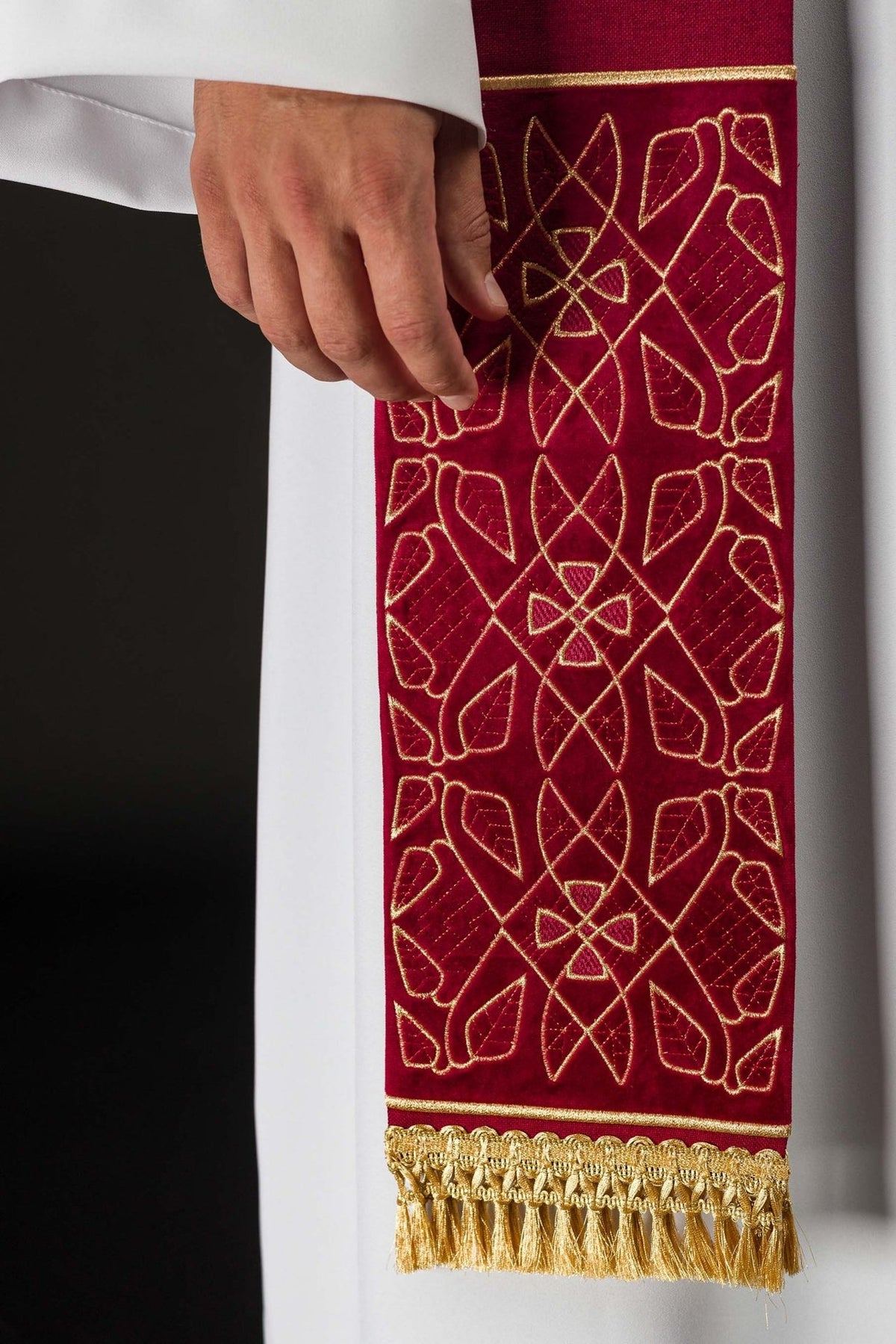 Red velvet stole, close-up of repeating gold embroidery and fringe
