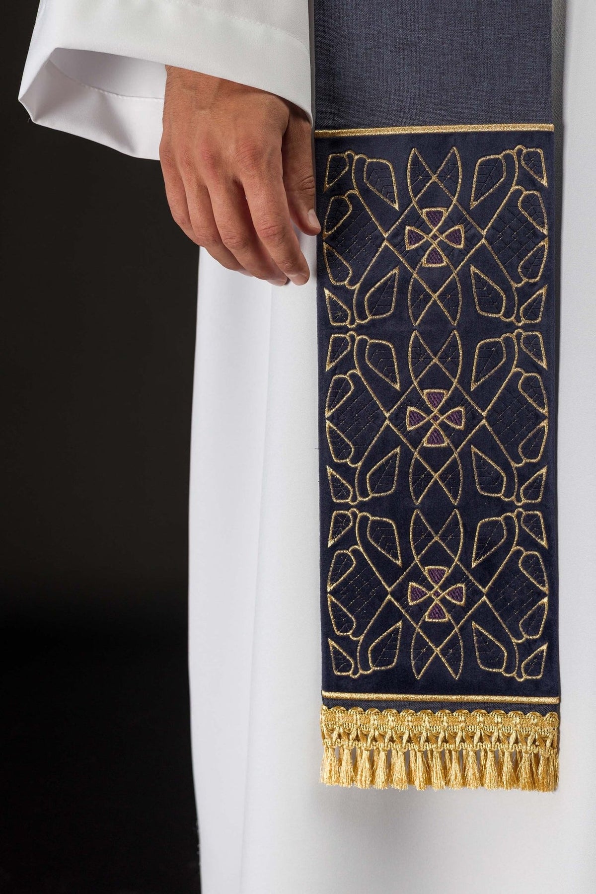 Purple velvet stole detail showing embroidered geometric pattern and gold fringe