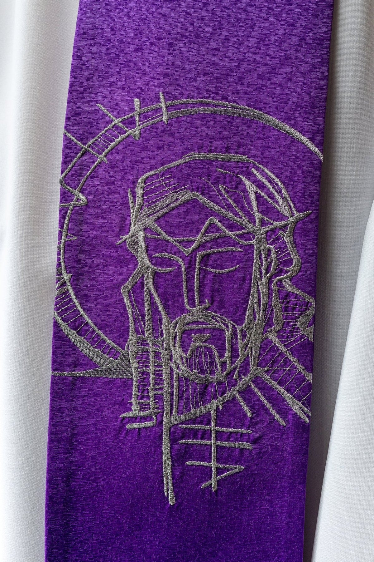 Lent stole close-up showing silver embroidered Jesus wearing a crown of thorns