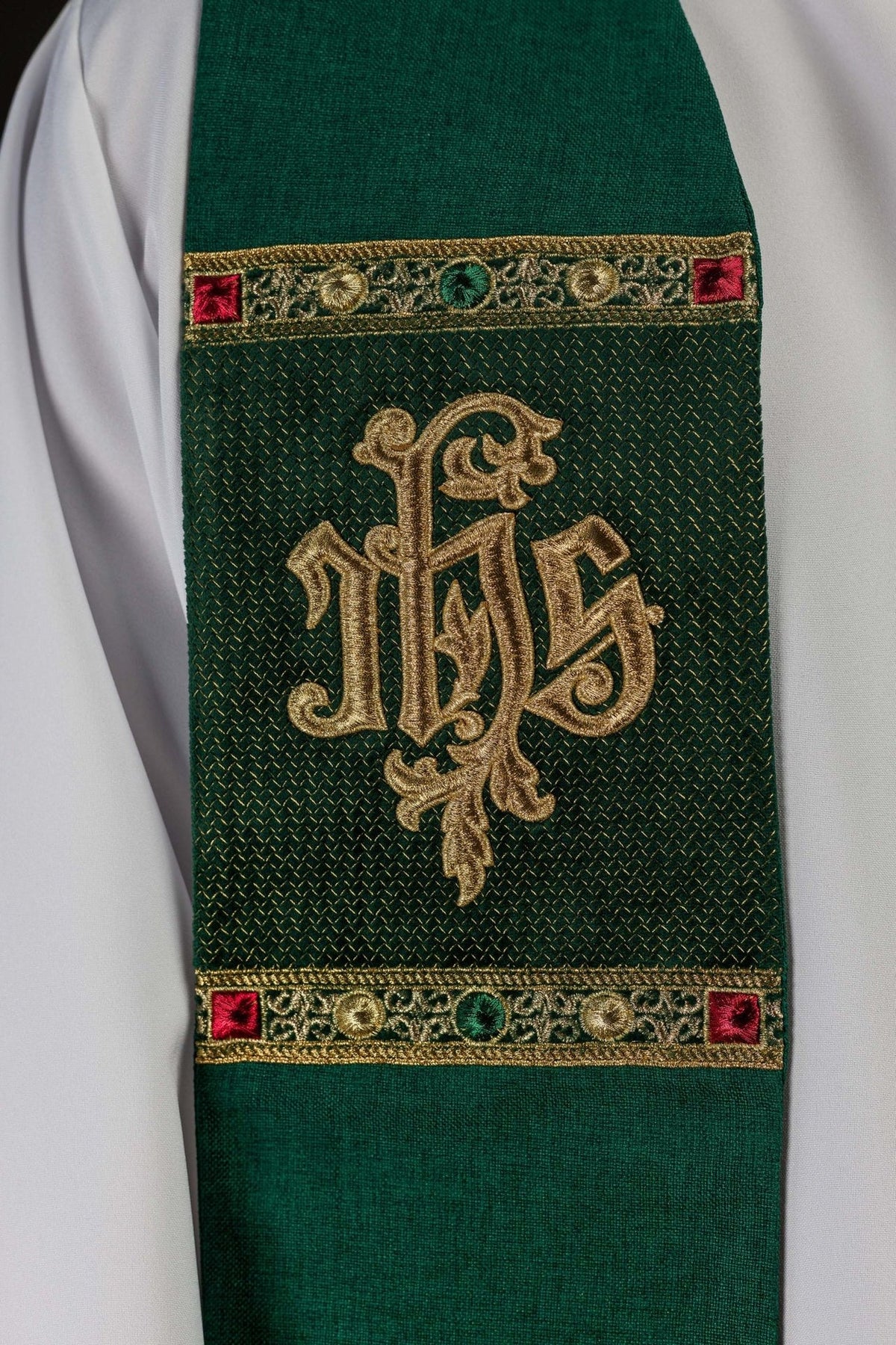Green stole close-up with gold IHS embroidery and decorative bands