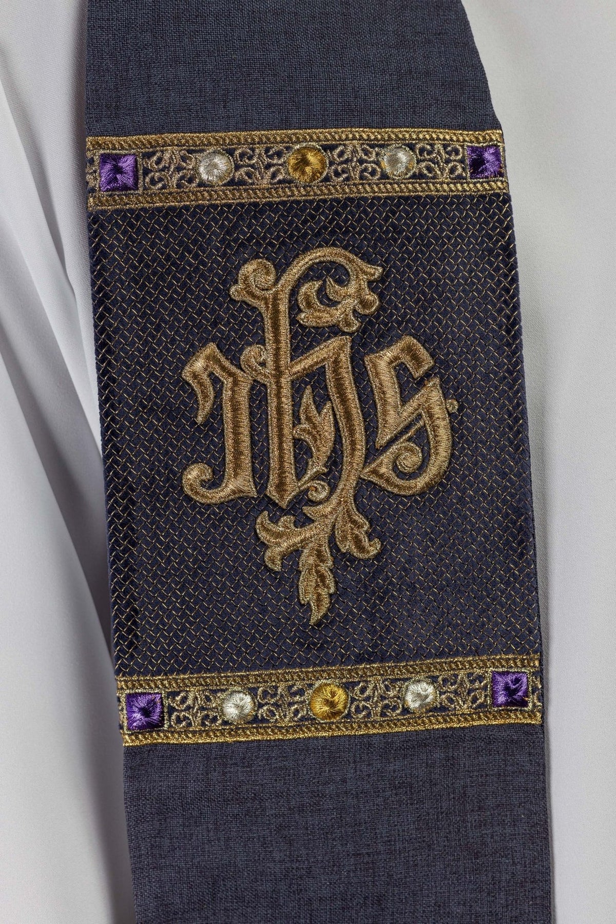 Stole close-up showing gold IHS embroidery and purple, gold, silver decorative bands