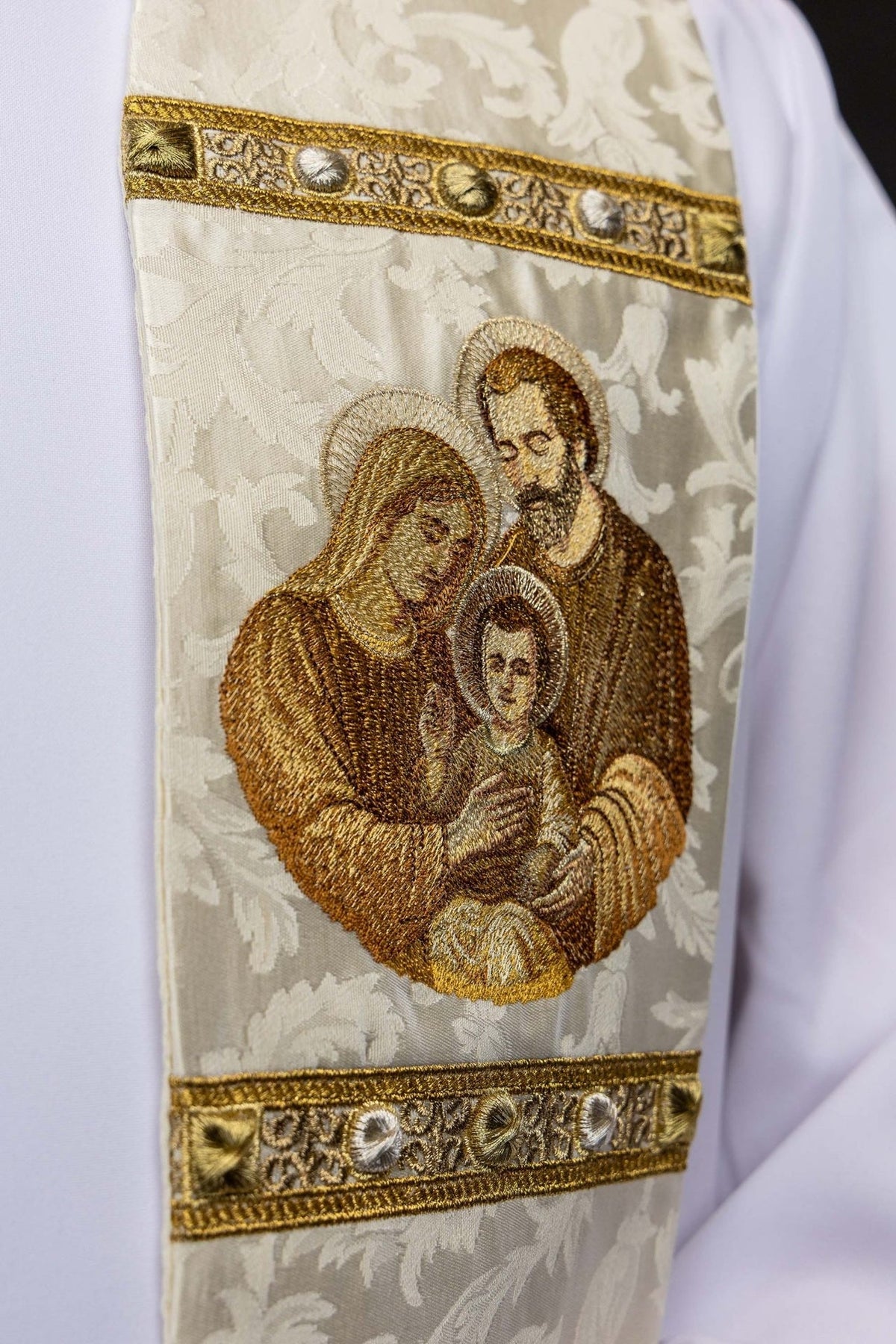 Stole close-up showing embroidered Holy Family motif on ecru jacquard fabric
