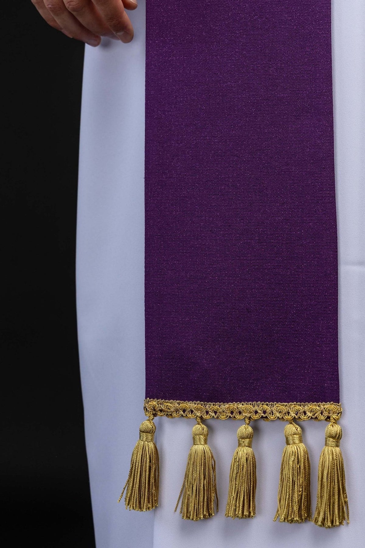 Advent stole detail showing plain purple fabric, gold trim and hanging tassels