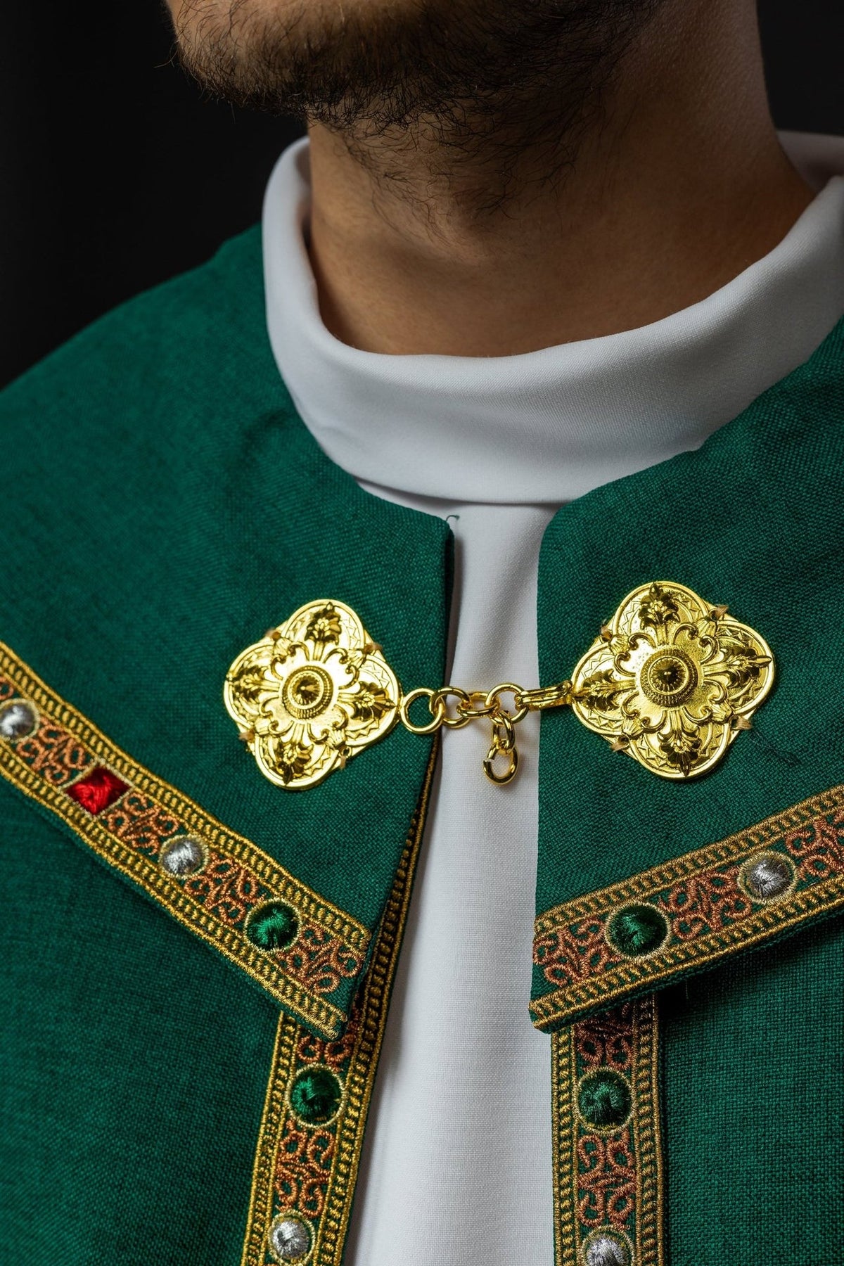 Green cope close-up showing white collar and gold floral clasp